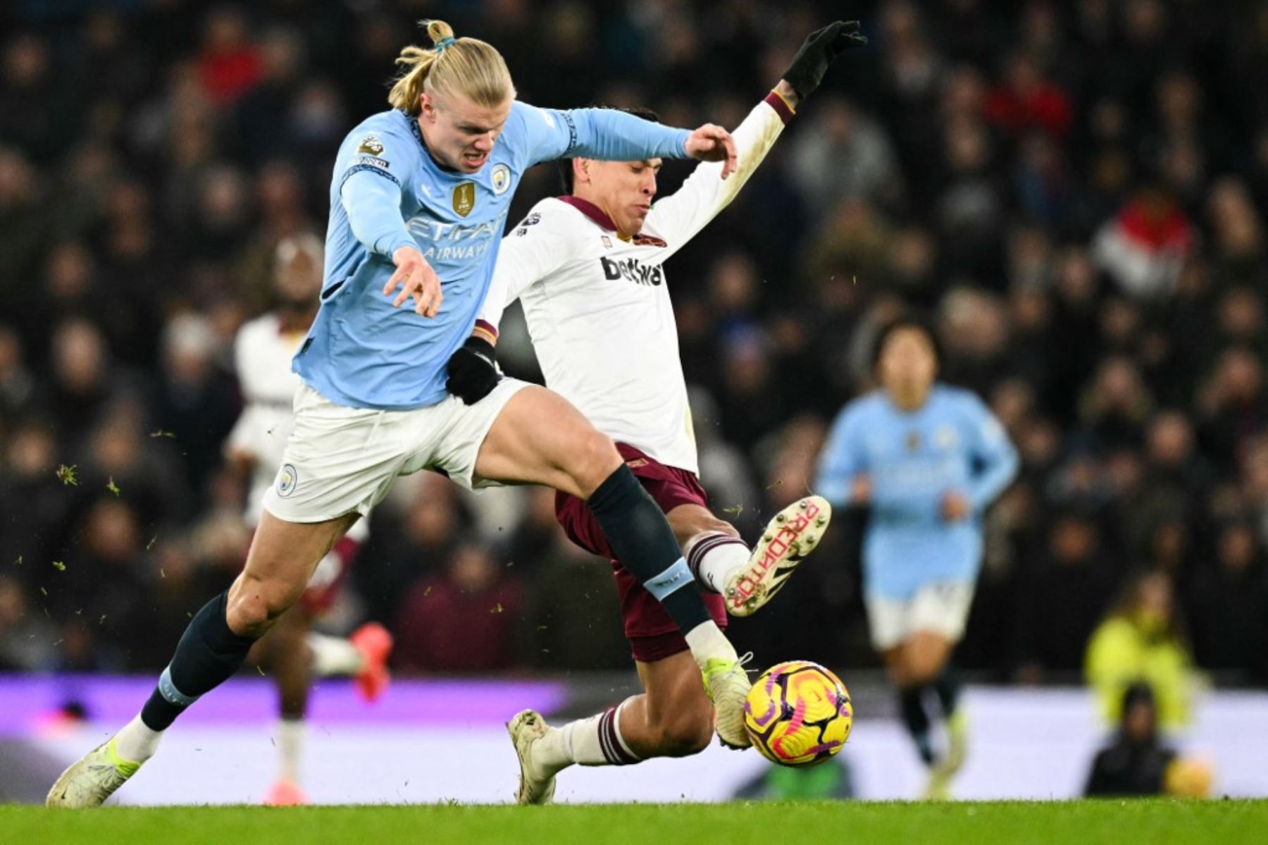 El delantero noruego del Manchester City #09 Erling Haaland (L) lucha por el balón con el centrocampista mexicano del West Ham United, Edson Álvarez (R), durante el partido de fútbol de la Premier League inglesa entre el Manchester City y el West Ham United en el Etihad Stadium de Manchester, noroeste de Inglaterra, el 4 de enero de 2025. (Foto de Oli SCARFF / AFP)