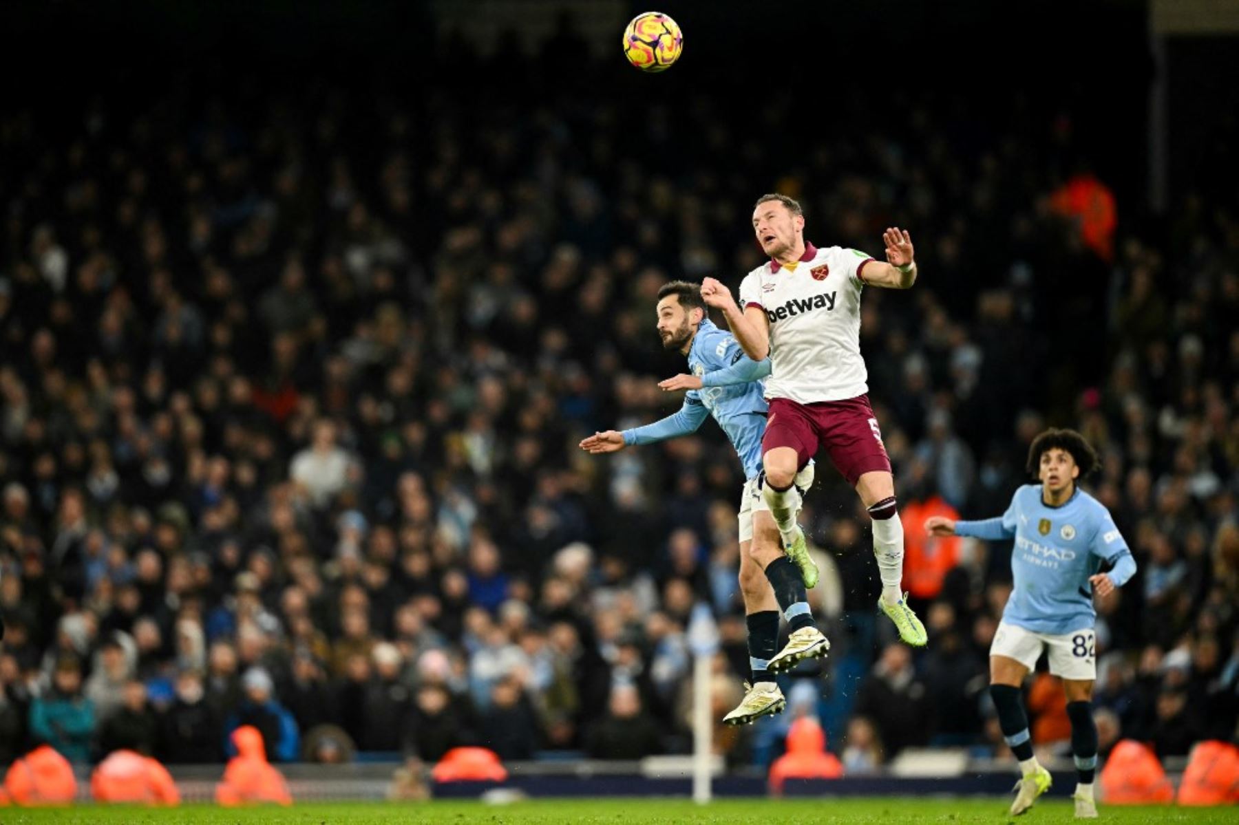 El centrocampista portugués del Manchester City #20 Bernardo Silva (L) y el defensor checo #05 del West Ham United, Vladimir Coufal encabezan el balón mientras luchan por él durante el partido de fútbol de la Premier League inglesa entre el Manchester City y el West Ham United en el Etihad Stadium de Manchester, al noroeste de Inglaterra, el 4 de enero de 2025. (Foto de Oli SCARFF / AFP)