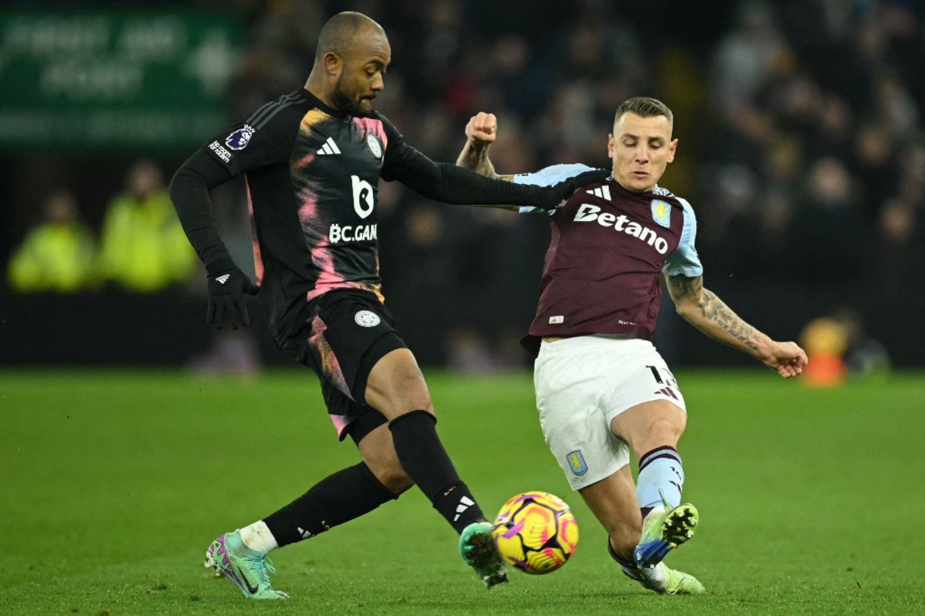 El delantero de Ghana #18 del Leicester City, Jordan Ayew (L), compite con el defensa francés #12 del Aston Villa, Lucas Digne (R), durante el partido de fútbol de la Premier League inglesa entre Aston Villa y Leicester City en Villa Park en Birmingham, en el centro de Inglaterra, el 4 de enero de 2025. (Foto de JUSTIN TALLIS / AFP)