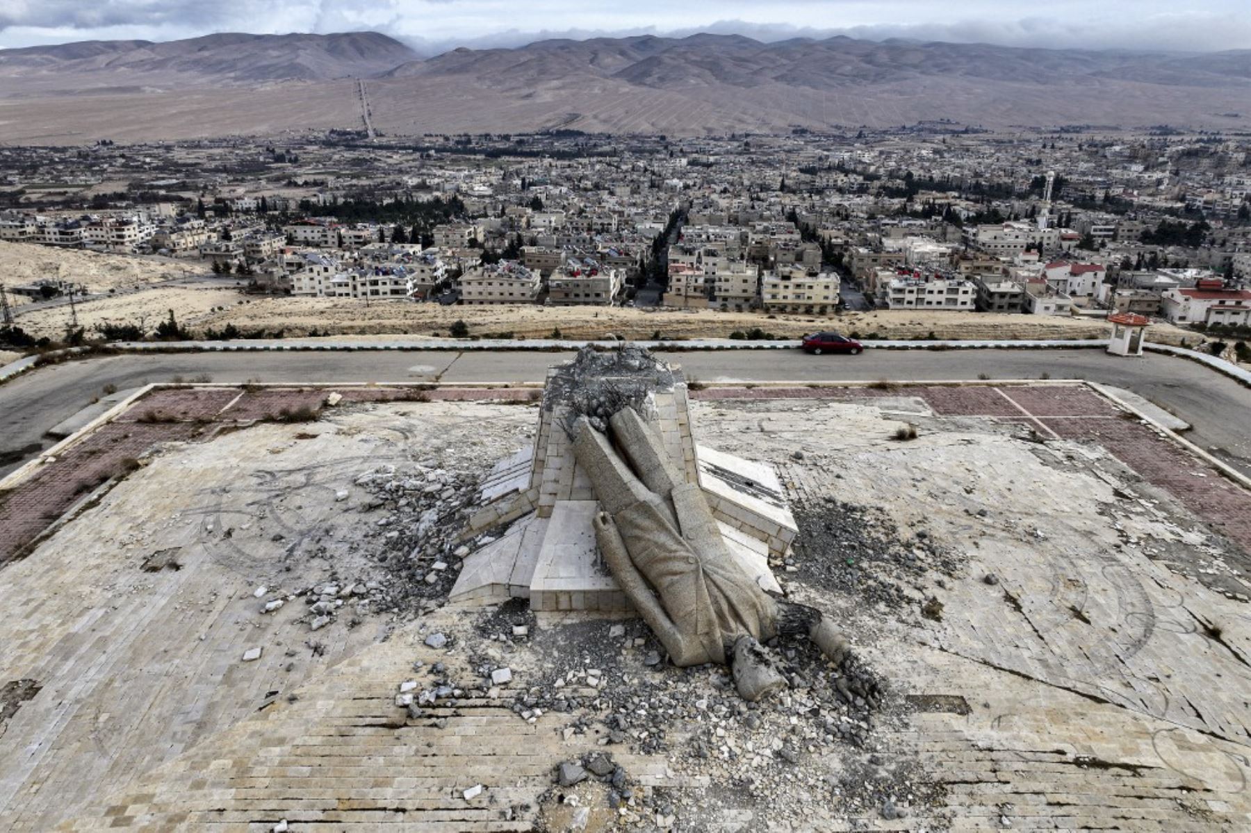 Esta vista aérea muestra los restos de un monumento destruido al difunto presidente de Siria Hafez al-Assad, padre del presidente derrocado Bashar al-Assad que murió en 2000, en Deir Attiyah, en el campo de Damasco, el 28 de diciembre de 2024. El monumento en Deir Attiyah fue la estatua más grande de Hafez al-Assad hasta que fue destruido el 8 de diciembre después de que Bashar al-Assad huyera del país y los rebeldes islamistas tomaron la capital Damasco. (Foto de Omar HAJ KADOUR / AFP)