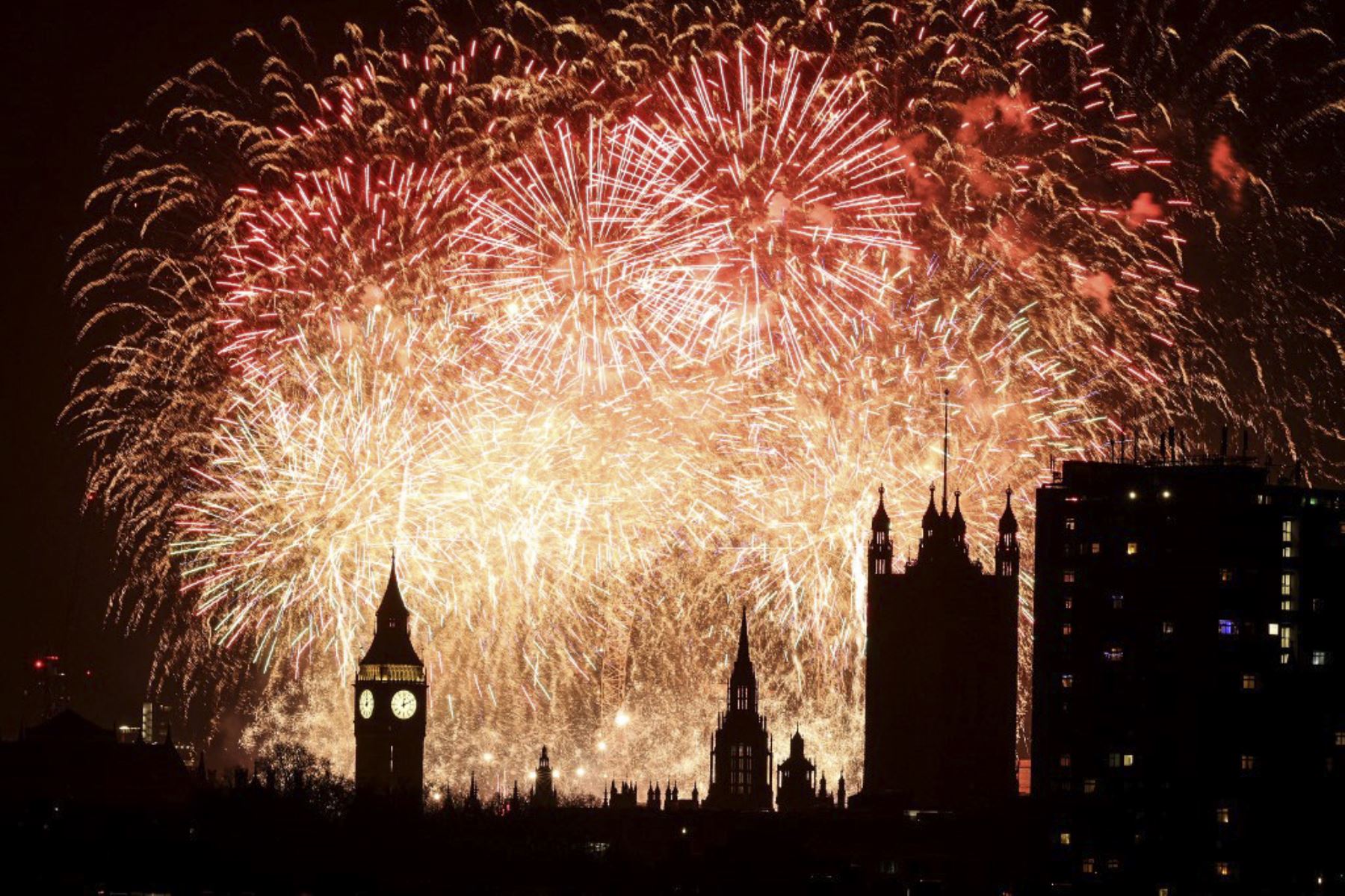 Los fuegos artificiales explotan en el cielo alrededor del London Eye y la Torre Elizabeth, comúnmente conocida por el nombre de la campana del reloj, "Big Ben", en el Palacio de Westminster, hogar de las Casas del Parlamento, en el centro de Londres, justo después de la medianoche del 1 de enero de 2025. (Foto de Adrian Dennis / AFP)