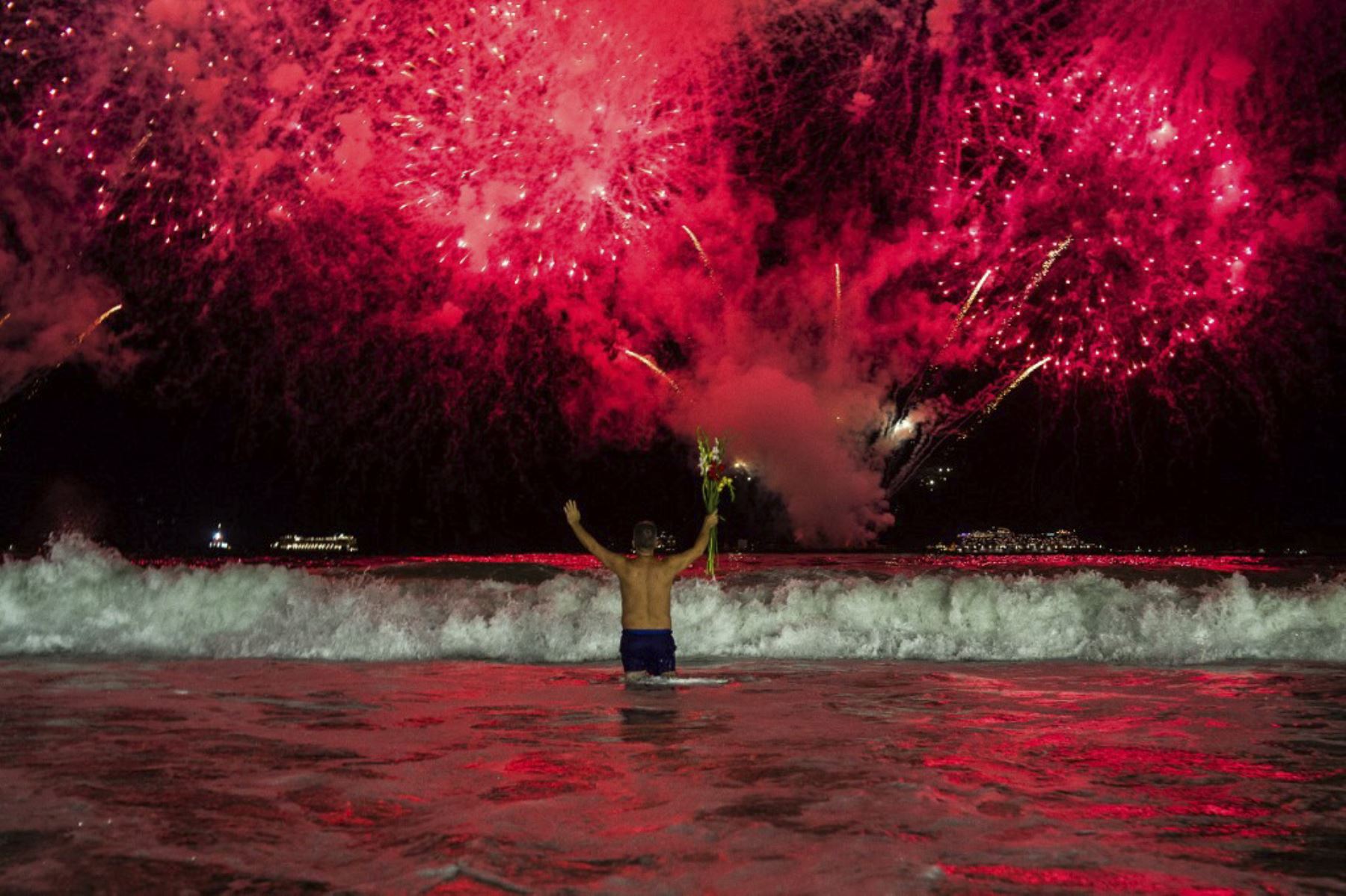 Una persona observa los tradicionales fuegos artificiales de Año Nuevo desde el agua en la playa de Copacabana en Río de Janeiro, Brasil, temprano el 1 de enero de 2025. Se llevará a cabo un espectáculo tradicional de fuegos artificiales y conciertos de música gratuitos para dar la bienvenida al nuevo año durante la celebración de la víspera de Año Nuevo en Río de Janeiro. La oficina de prensa del alcalde de Río la considera la celebración de Nochevieja más grande del mundo, con 2 millones de personas que s