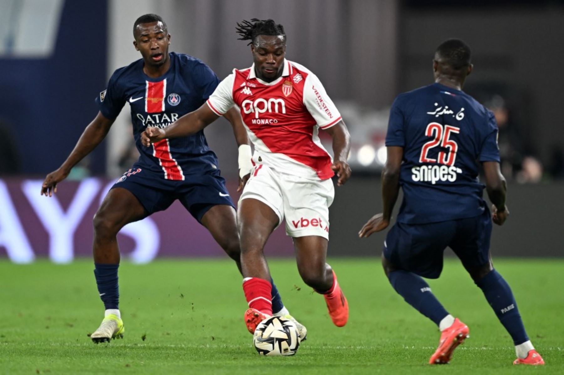 El delantero nigeriano-francés #21 del Mónaco, George Ilenikhena, corre con el balón más allá del defensor portugués del Paris Saint-Germain #25, Nuno Mendes, durante el último partido de fútbol del Trofeo de Campeones de Francia entre el Paris Saint-Germain (PSG) y el AS Mónaco (ASM) en el Estadio 974 de Doha el 5 de enero de 2025. (Foto de Mahmud HAMS / AFP)