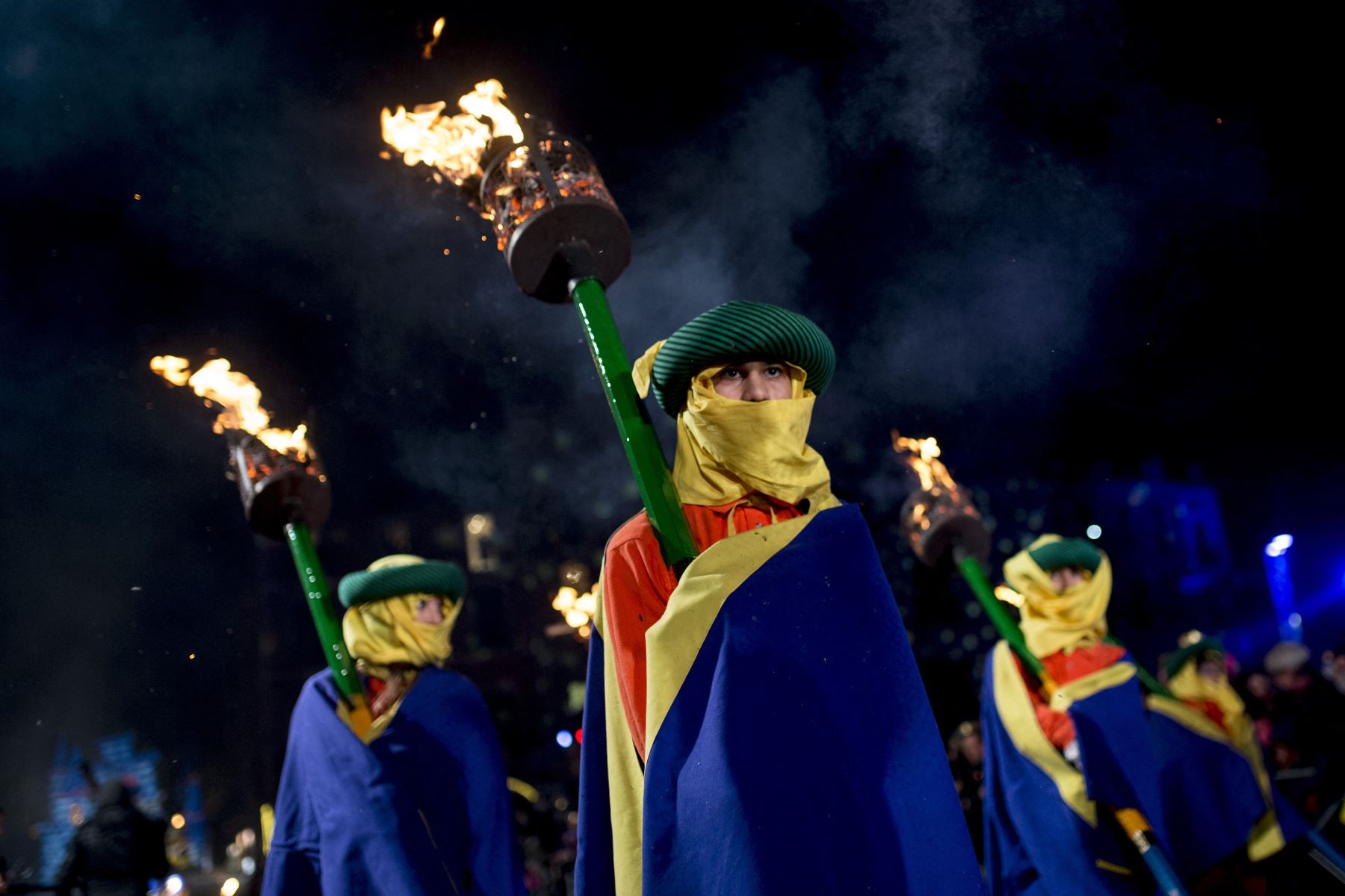 Participantes disfrazados sostienen antorchas mientras desfilan durante la Cabalgata de los Reyes Magos, marcando la víspera de la fiesta de la Epifanía.
Foto: AFP