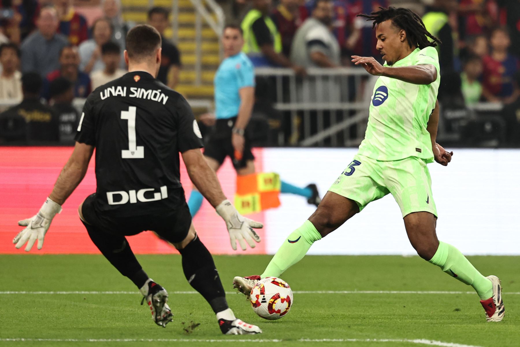 El portero español del Athletic de Bilbao #1 Unai Simon cierra al defensor francés del Barcelona #23 Jules Kounde durante el partido de fútbol semifinal de la Supercopa de España entre el Athletic de Bilbao y Barcelona. AFP