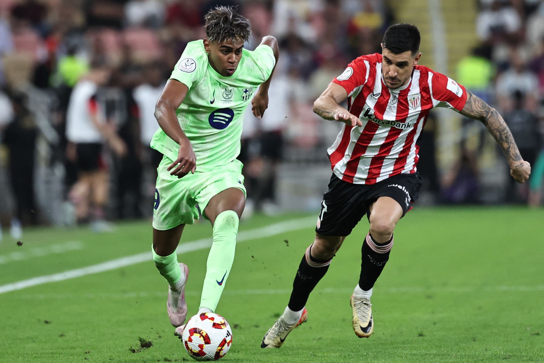 El delantero español del Barcelona  Lamine Yamal está marcado por el defensor español del Athletic de Bilbao  Yuri Berchiche durante el partido de fútbol semifinal de la Supercopa de España entre el Athletic de Bilbao y Barcelona. AFP