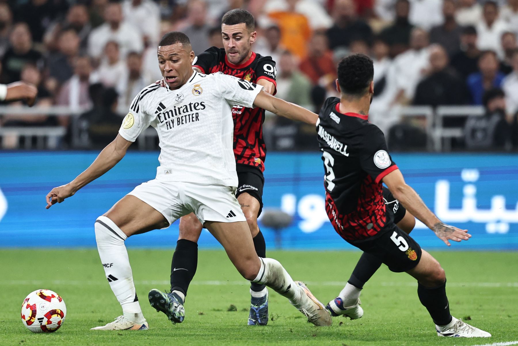 El delantero francés del Real Madrid Kylian Mbappé regatea al centrocampista de Guinea Ecuatorial  del Real Mallorca Omar Mascarell González durante el partido de fútbol semifinal de la Supercopa de España entre el Real Madrid y Mallorca. AFP