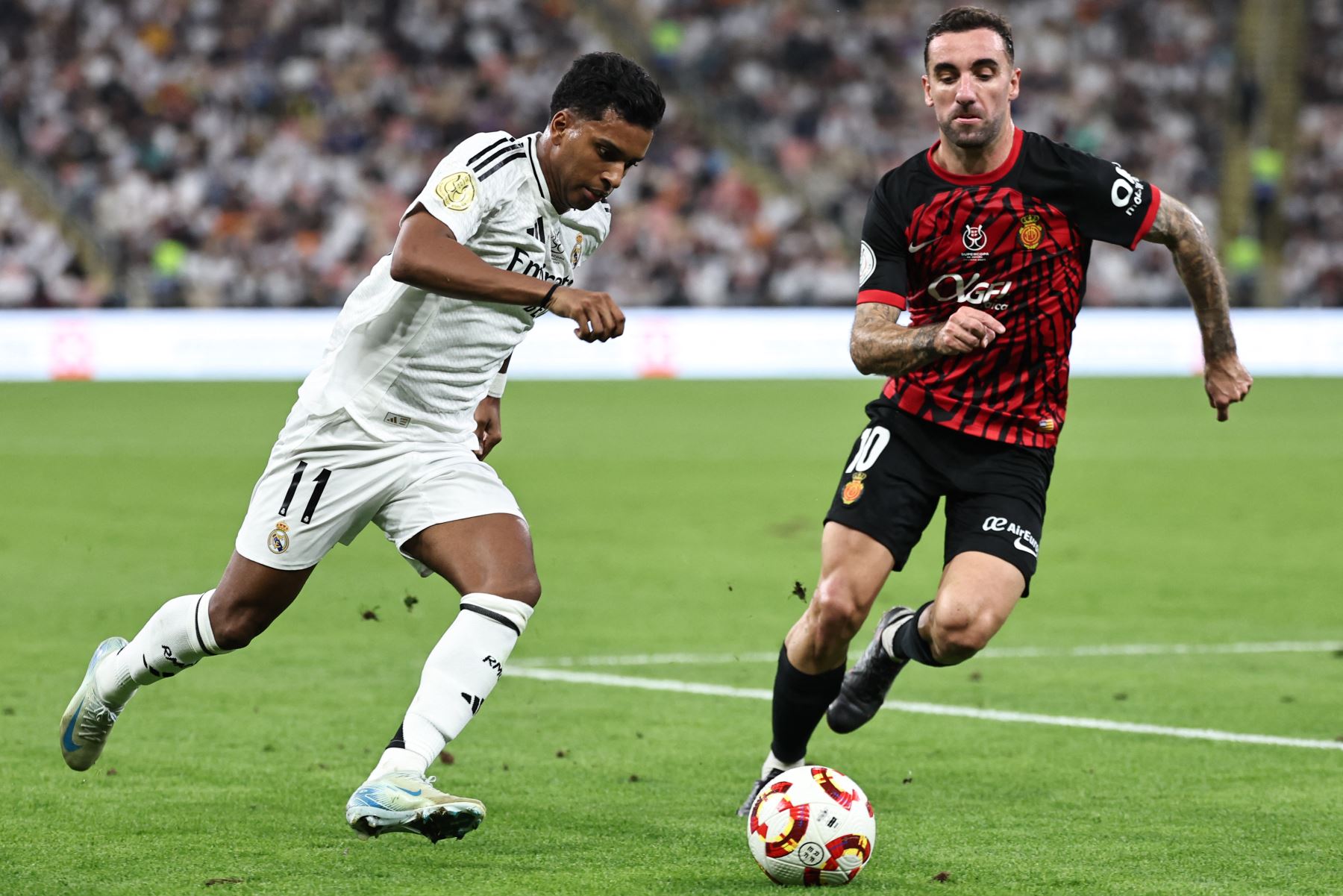 El delantero brasileño del Real Madrid  Rodrygo está marcado por el centrocampista español del Real Mallorca  Sergi Darder durante el partido de fútbol semifinal de la Supercopa de España entre el Real Madrid y Mallorca. AFP