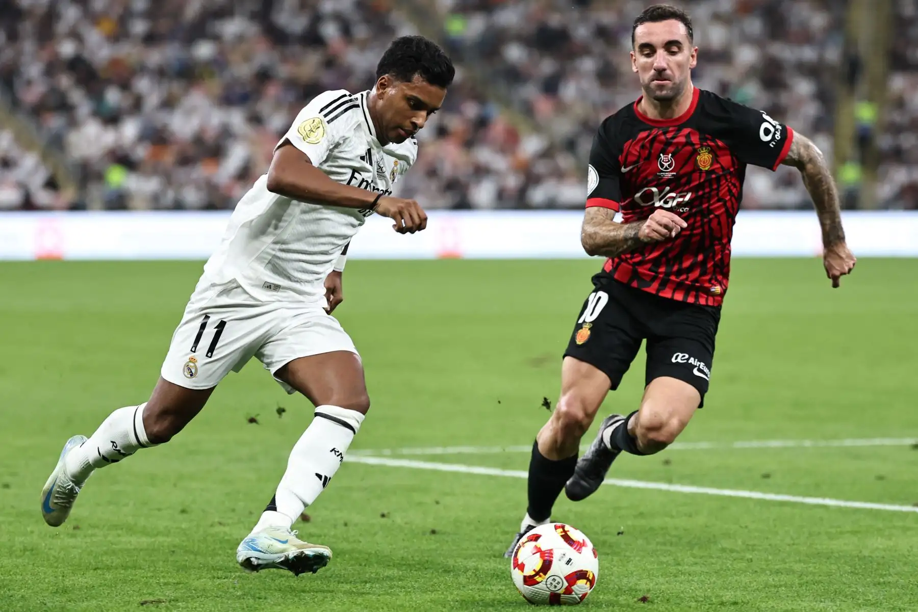 El delantero brasileño del Real Madrid  Rodrygo está marcado por el centrocampista español del Real Mallorca  Sergi Darder durante el partido de fútbol semifinal de la Supercopa de España entre el Real Madrid y Mallorca. AFP