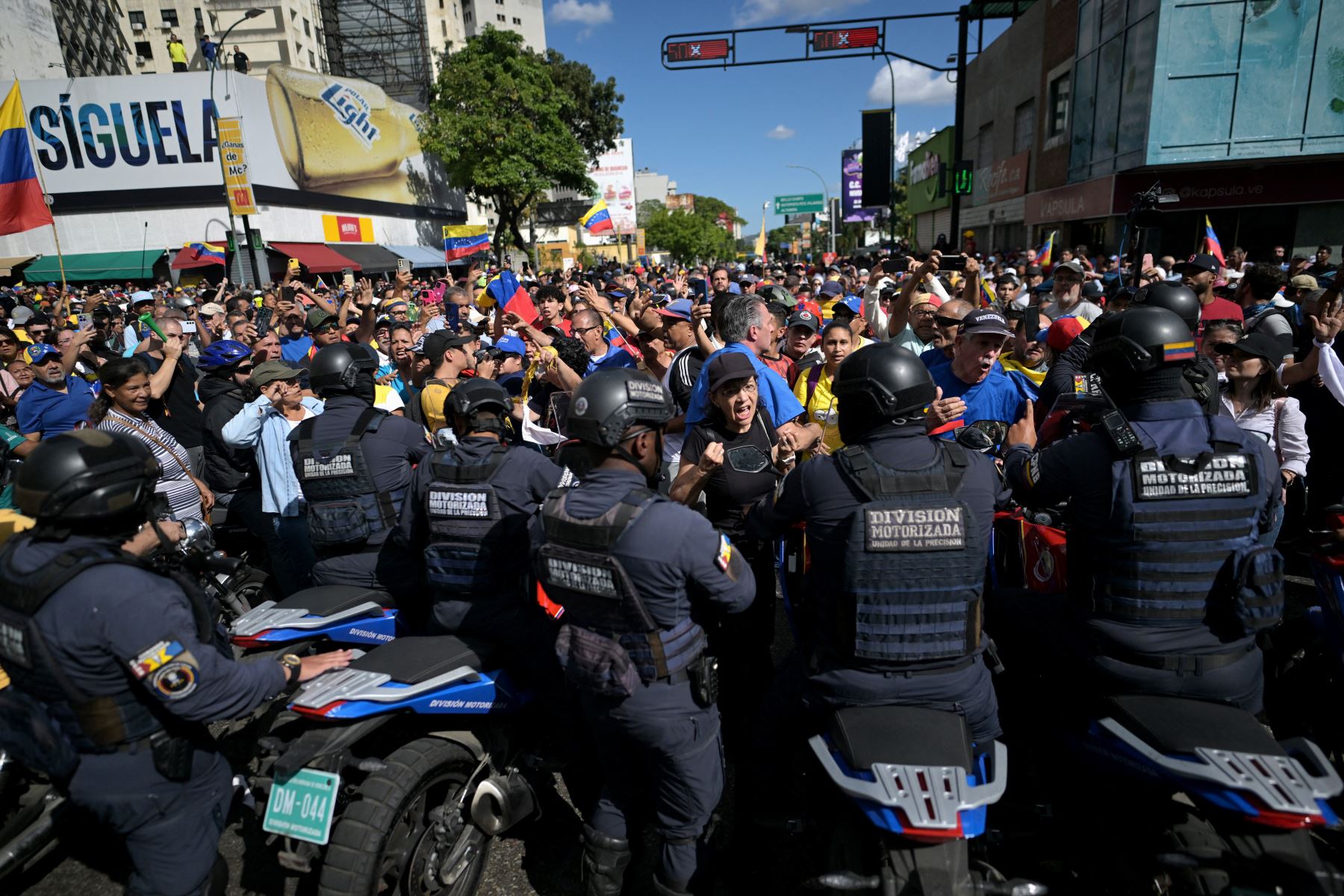 Los manifestantes bloquean a los miembros de la división motorizada de la policía después de que la líder de la oposición venezolana María Corina Machado pronunció un discurso durante una protesta convocada por la oposición en vísperas de la toma de posesión presidencial. AFP