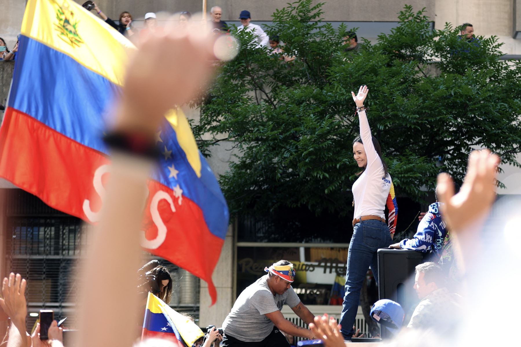 La líder opositora venezolana María Corina Machado saluda durante una protesta convocada por la oposición en vísperas de la toma de posesión presidencial, en Caracas. AFP