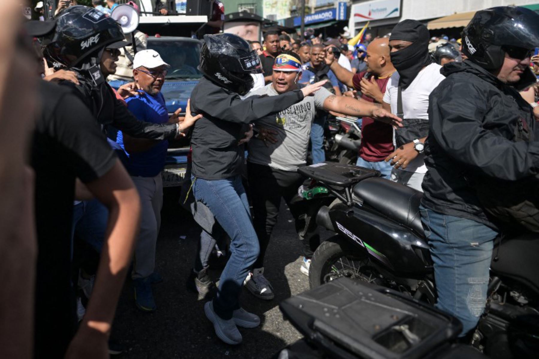 La líder de la oposición venezolana María Corina Machado, se sube a una motocicleta después de pronunciar un discurso durante una manifestación convocada por la oposición en vísperas de la toma de posesión presidencial en Caracas. Foto: AFP