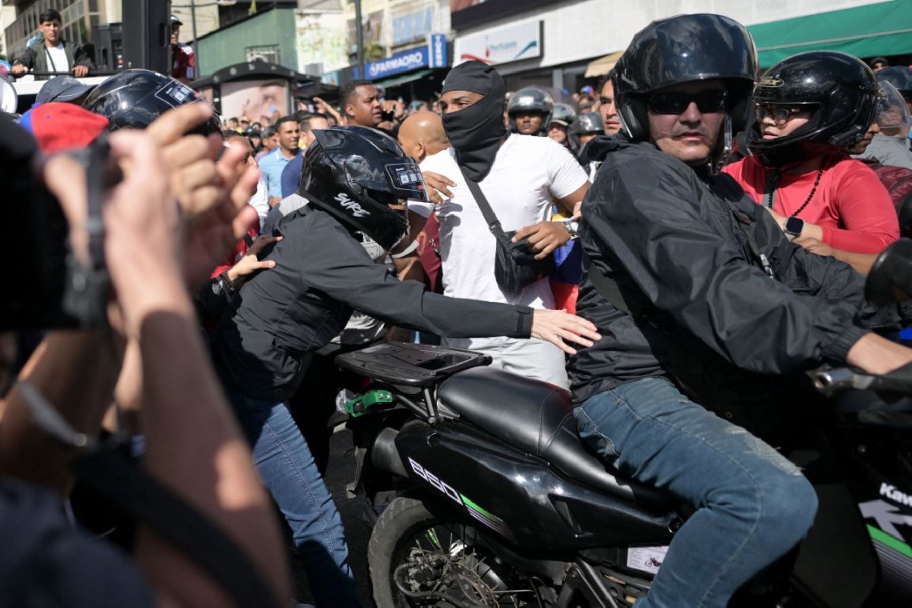 La líder de la oposición venezolana María Corina Machado, se sube a una motocicleta después de pronunciar un discurso durante una manifestación convocada por la oposición en vísperas de la toma de posesión presidencial en Caracas. Foto: AFP