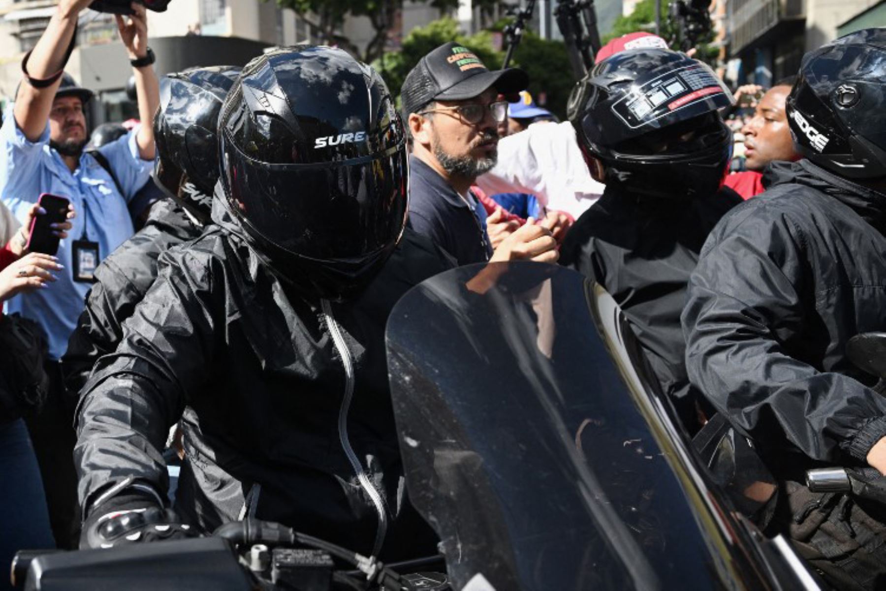 La líder de la oposición venezolana María Corina Machado, se sube a una motocicleta después de pronunciar un discurso durante una manifestación convocada por la oposición en vísperas de la toma de posesión presidencial en Caracas. Foto: AFP