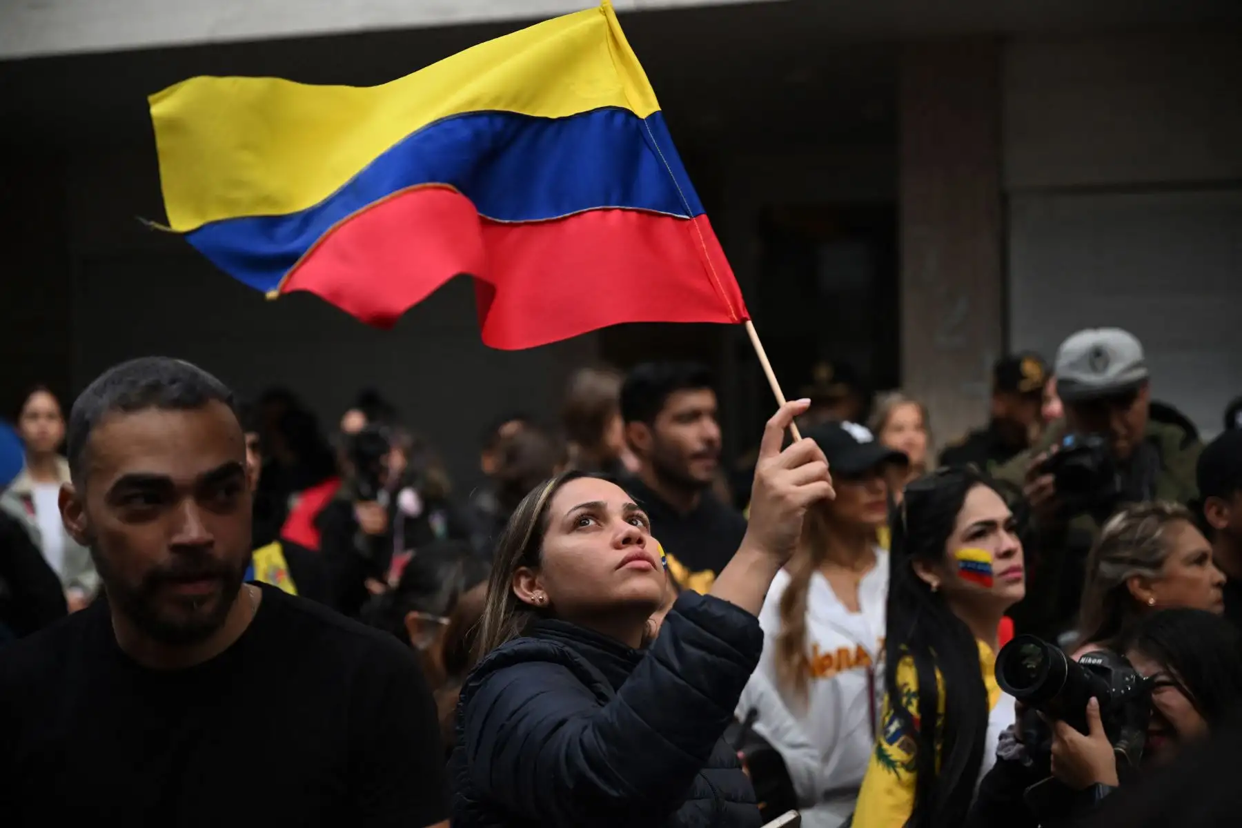 Una mujer ondea una bandera venezolana durante una protesta convocada por la oposición en vísperas de la toma de posesión presidencial en México. AFP