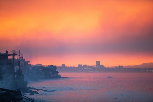 El humo de los incendios forestales y las casas quemadas por el incendio Palisades se ven en la madrugada del 10 de enero de 2025 en el barrio de Pacific Palisades de Los Ángeles, California. AFP