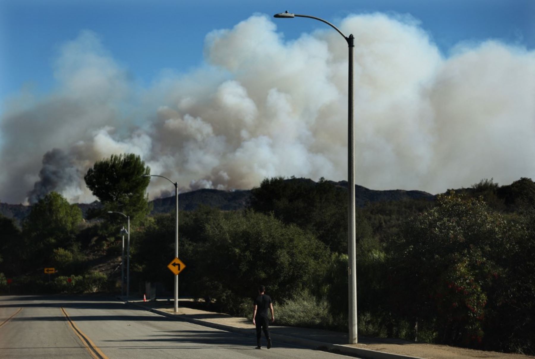 Una persona camina mientras el incendio de Palisades continúa ardiendo mientras los incendios forestales causan daños y pérdidas en el condado de Los Ángeles. Foto: AFP