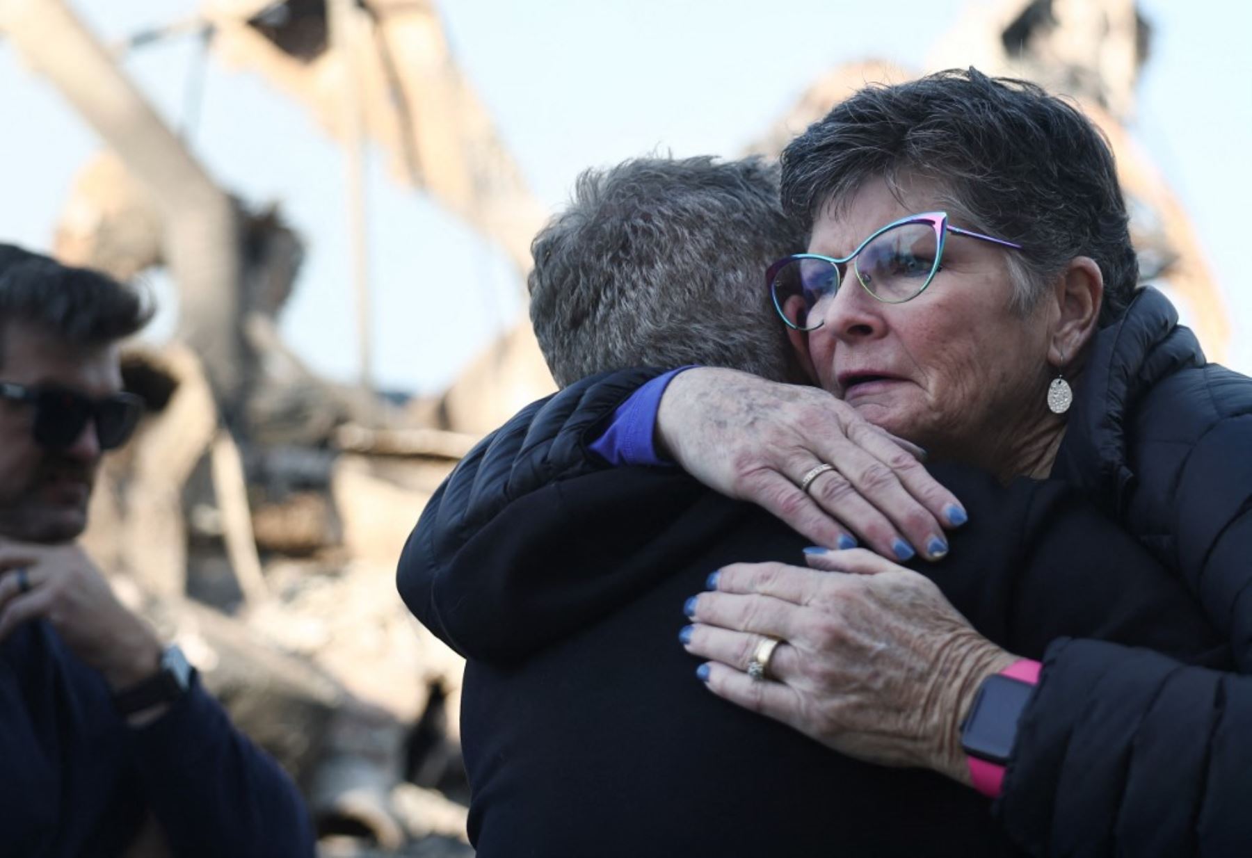 Un partidario (R) abraza al reverendo John Shaver después de visitar los restos de la Iglesia Metodista Unida de la Comunidad, donde es pastor, ya que los incendios forestales causan daños y pérdidas en el condado de Los Ángeles. Foto: AFP