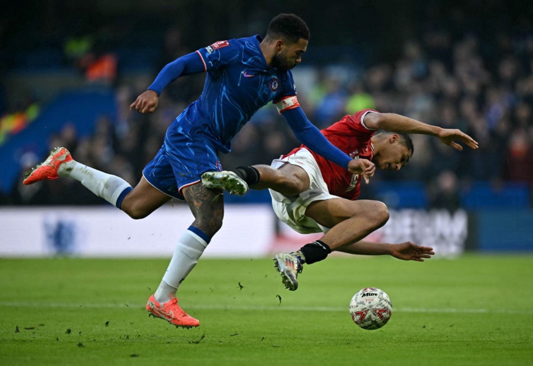 El defensor inglés del Chelsea #24 Reece James (L) comete una falta al delantero galés de Morecambe #19 Marcus Dackers durante el partido de fútbol de la tercera ronda de la Copa FA inglesa entre Chelsea y Morecambe en Stamford Bridge en Londres el 11 de enero de 2025. (Foto de Ben STANSALL / AFP)