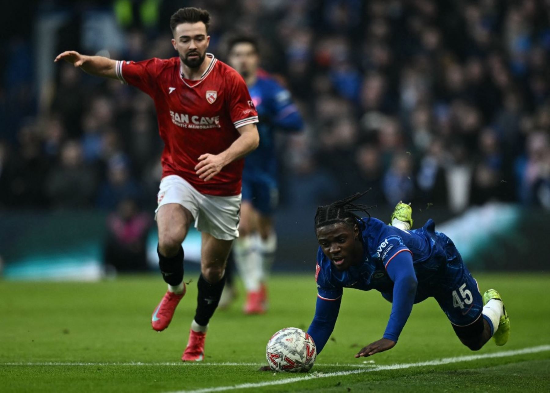 El centrocampista galés #07 de Morecambe, Gwion Edwards (L) comete una falta al centrocampista belga del Chelsea #45 Romeo Lavia durante el partido de fútbol de la tercera ronda de la Copa FA inglesa entre Chelsea y Morecambe en Stamford Bridge en Londres el 11 de enero de 2025. (Foto de Ben STANSALL / AFP)