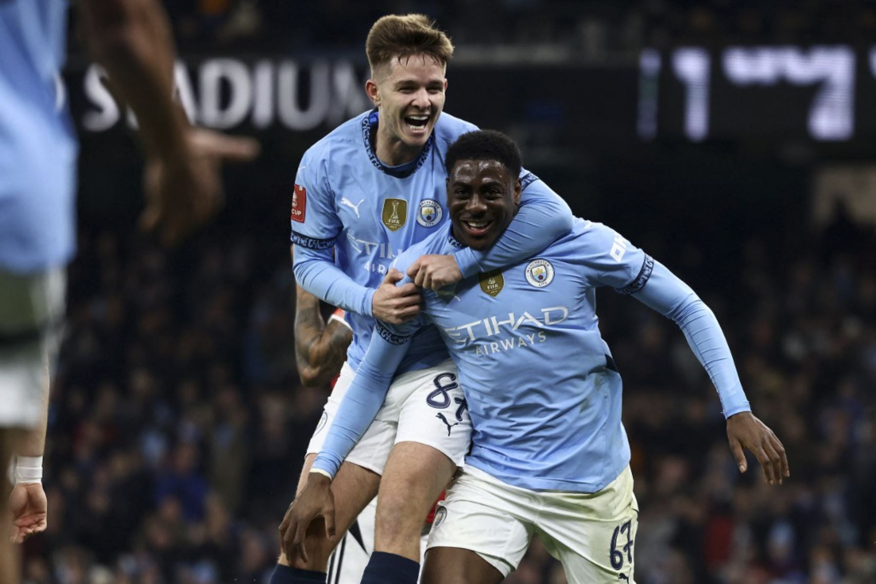 El delantero inglés del Manchester City #67 Divin Mubama (R) celebra el segundo gol del equipo con el centrocampista inglés del Manchester City #87 James McAtee durante el partido de fútbol de la tercera ronda de la Copa FA inglesa entre Manchester City y Salford City en el Etihad Stadium en Manchester, noroeste de Inglaterra, el 11 de enero de 2025. (Foto de Darren Staples / AFP)