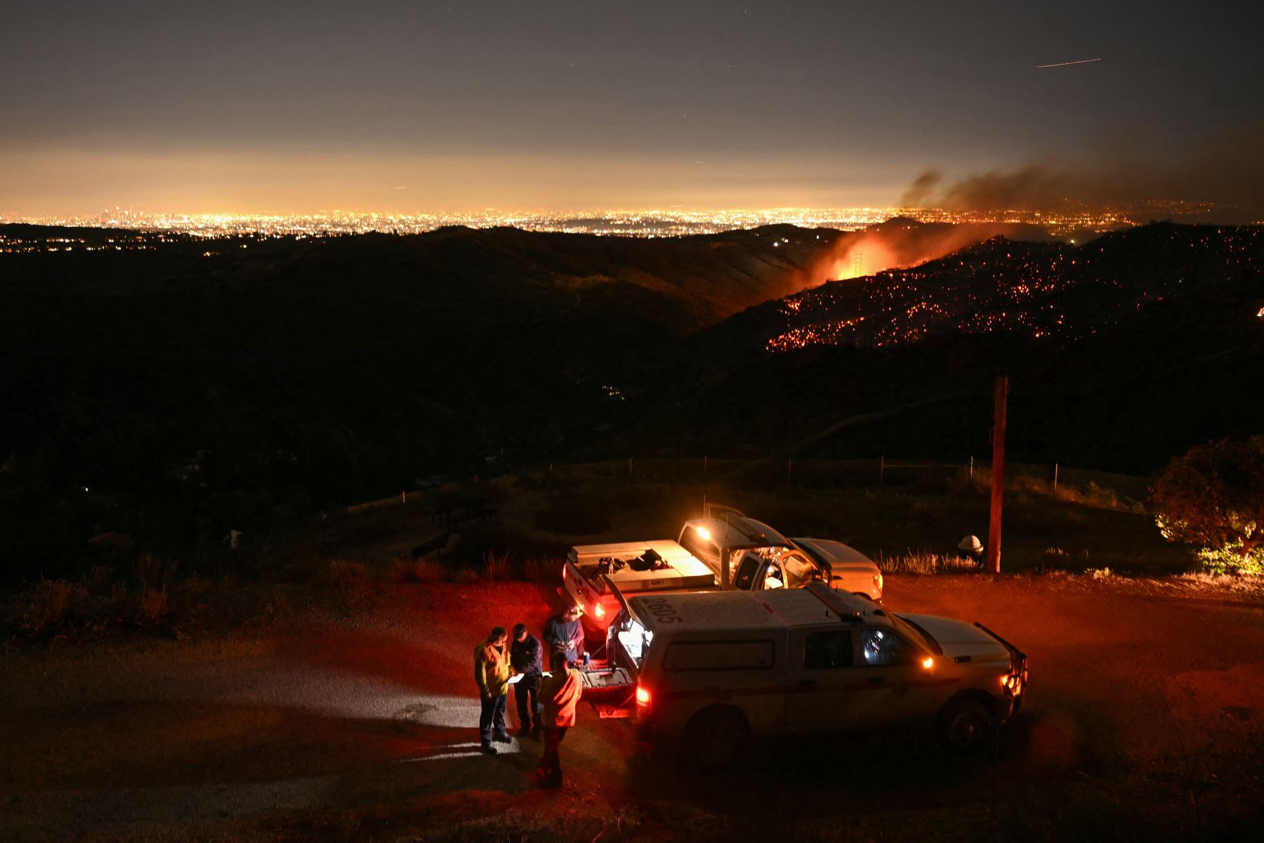 El horizonte del centro de Los Ángeles se ve a lo lejos mientras los bomberos monitorean el incendio de Palisades cerca del vecindario de Mandeville Canyon y Encino, California.
Foto: AFP