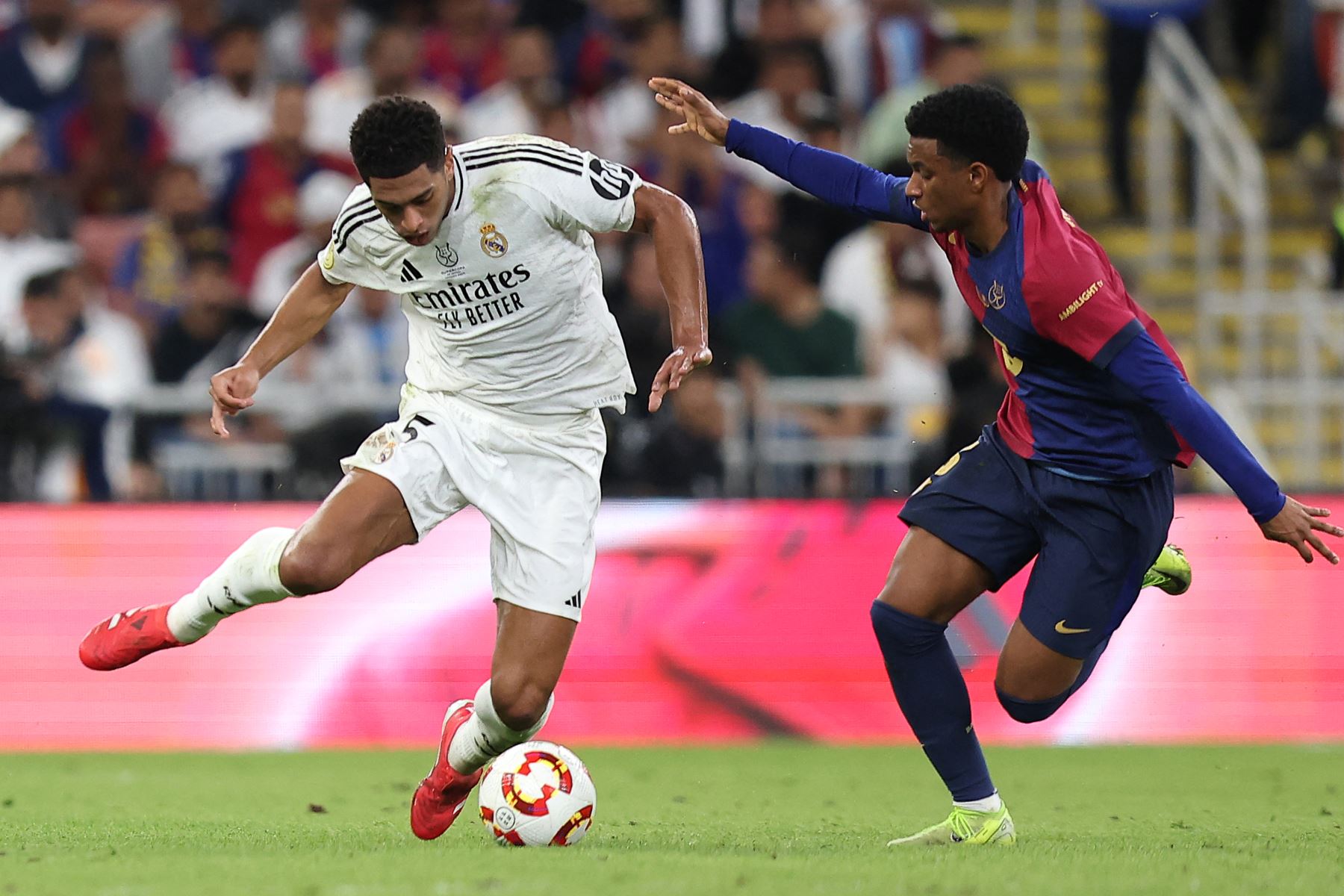 El mediocampista inglés del Real Madrid, Jude Bellingham controla el balón pasando al defensor español del Barcelona, Alex Balde durante el partido final de la Supercopa de España entre el Real Madrid y Barcelona.
Foto: AFP