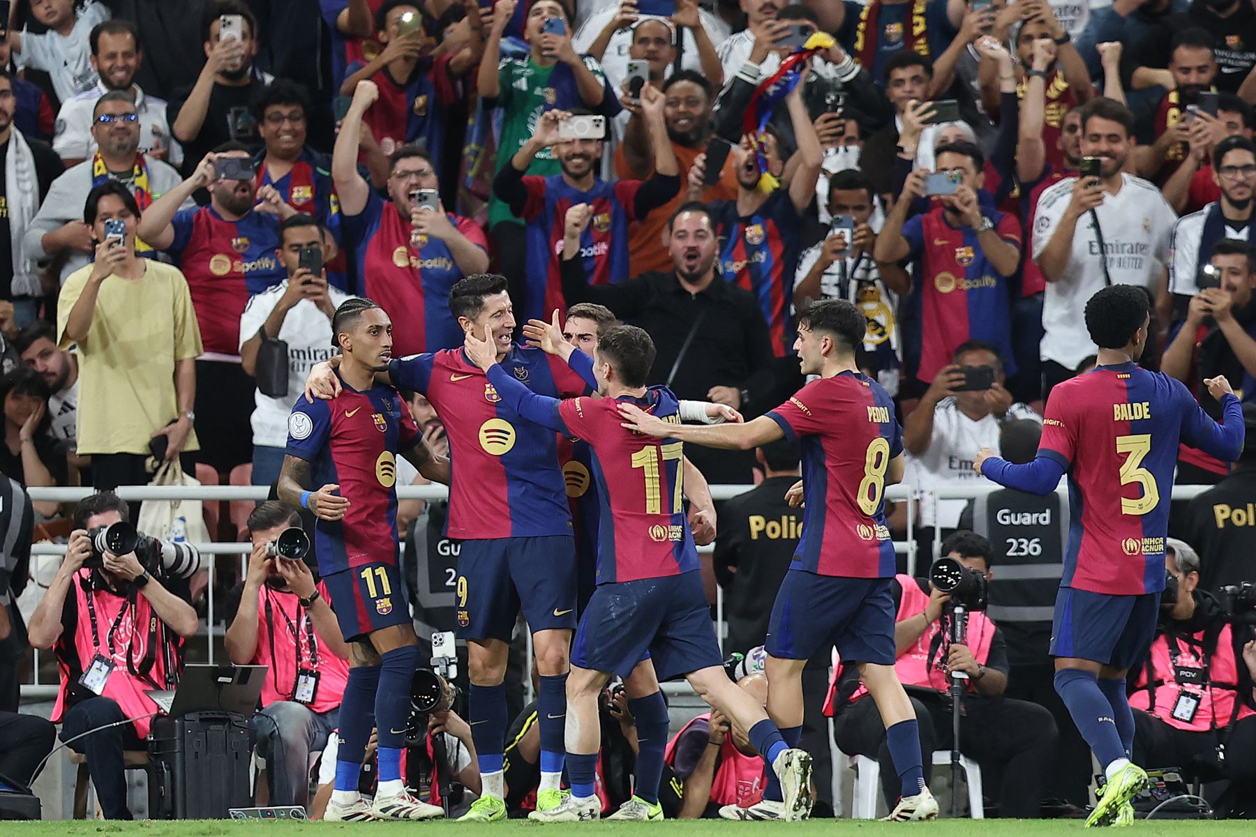 El delantero polaco del Barcelona, ​​Robert Lewandowski, celebra con sus compañeros de equipo después de marcar el segundo gol de su equipo durante la final de la Supercopa de España entre el Real Madrid y Barcelona.
Foto: AFP