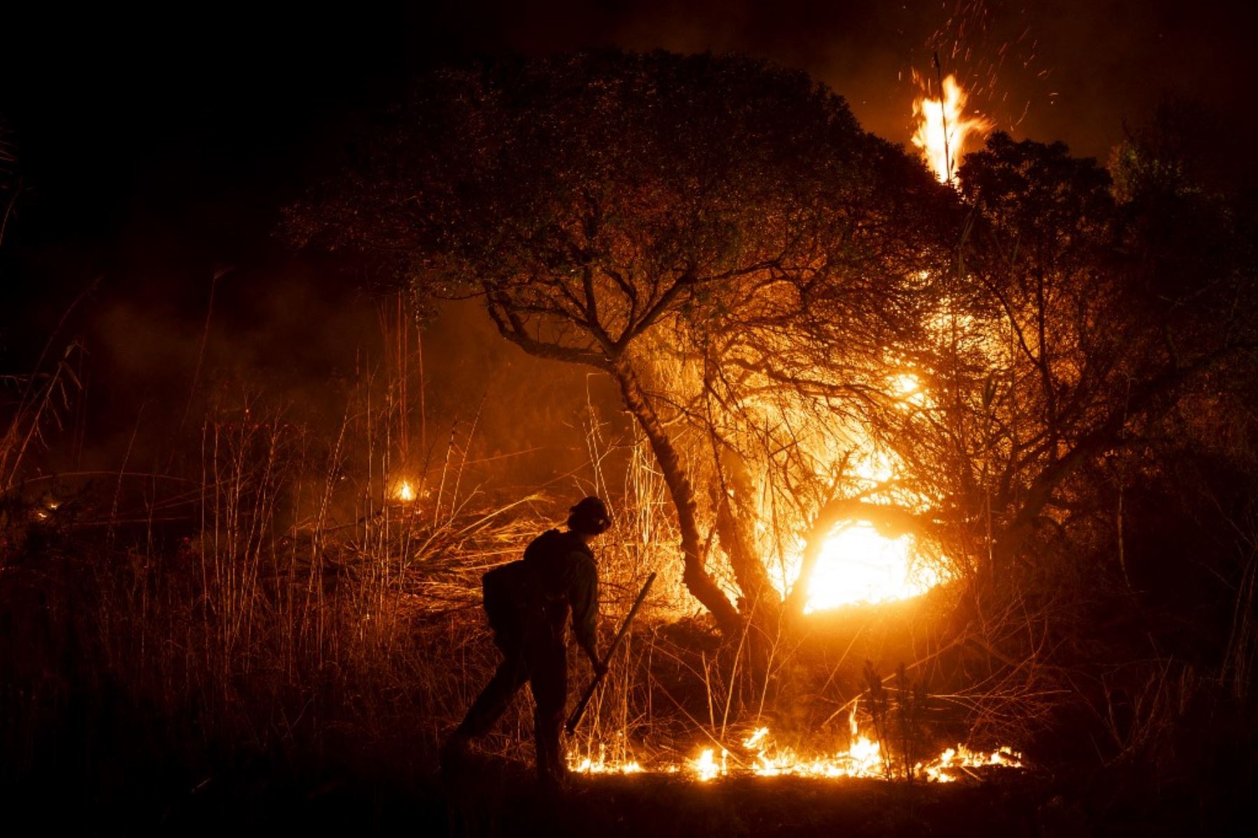 Un bombero monitorea la propagación del incendio en Oxnard, al noroeste de Los Ángeles, California. Foto: AFP