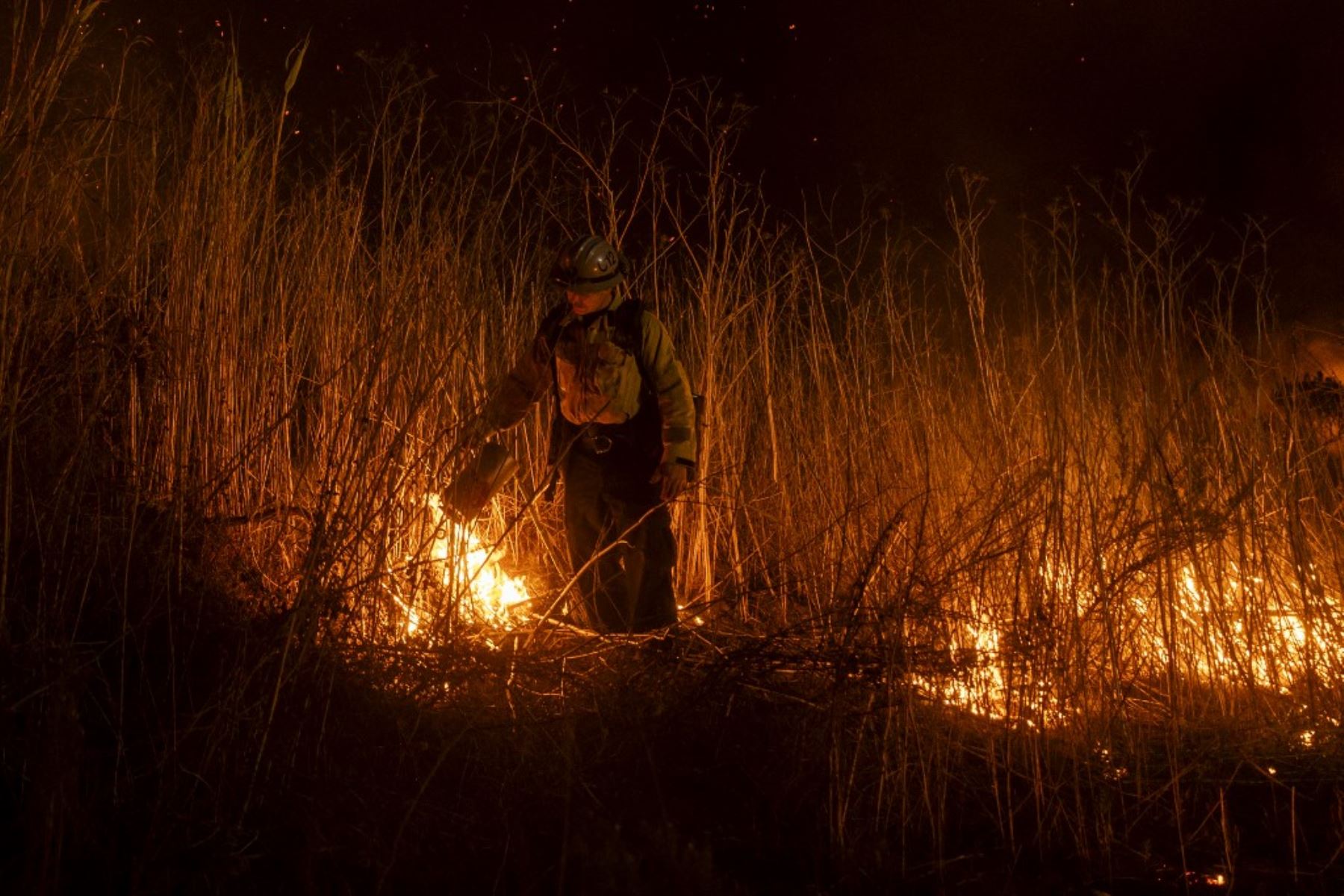 Un bombero enciende una bomba para controlar la propagación del incendio en Oxnard, al noroeste de Los Ángeles, California. Foto: AFP