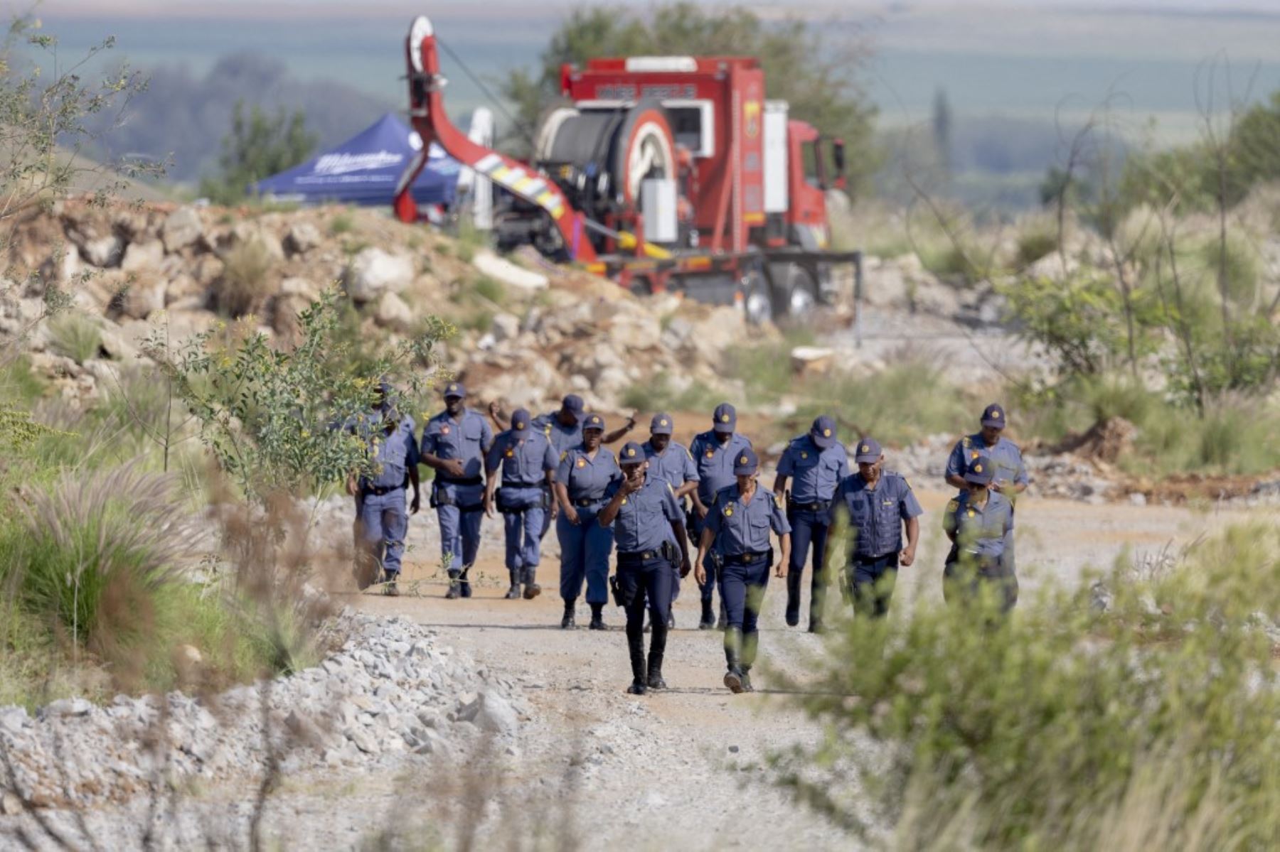 Oficiales del Servicio de Policía Sudafricano (SAPS) acuden a una operación de rescate para recuperar a mineros ilegales atrapados en un pozo de oro abandonado en Stilfontein, Sudáfrica, el 13 de enero de 2025. Los rescatistas sacaron a siete mineros ilegales y al menos cuatro cuerpos. Foto: AFP