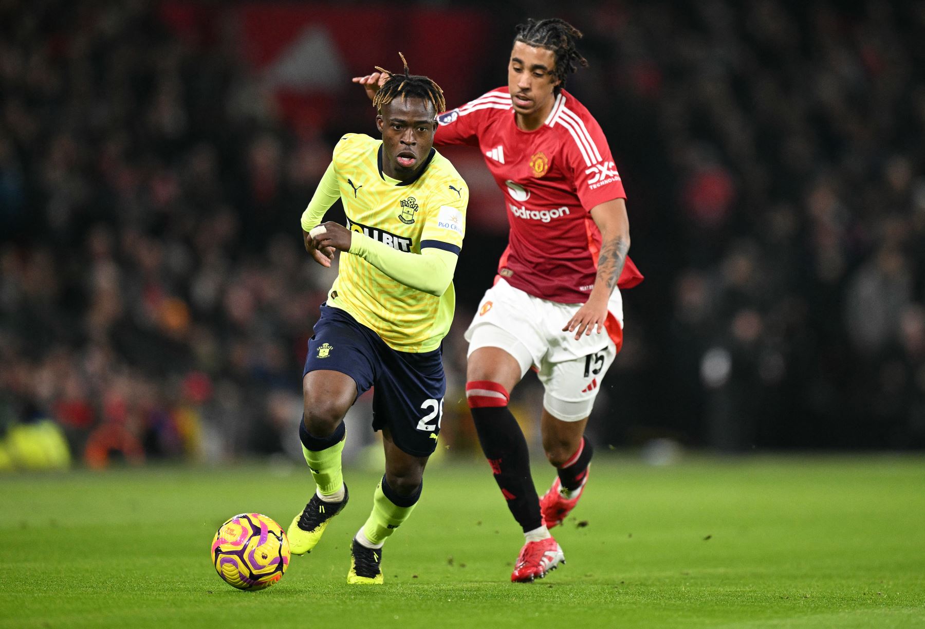 El defensor francés del Manchester United  Leny Yoro  compite con el centrocampista ghanés del Southampton  Kamaldeen Sulemana durante el partido de fútbol de la Premier League inglesa entre el Manchester United y el Southampton. Foto: AFP