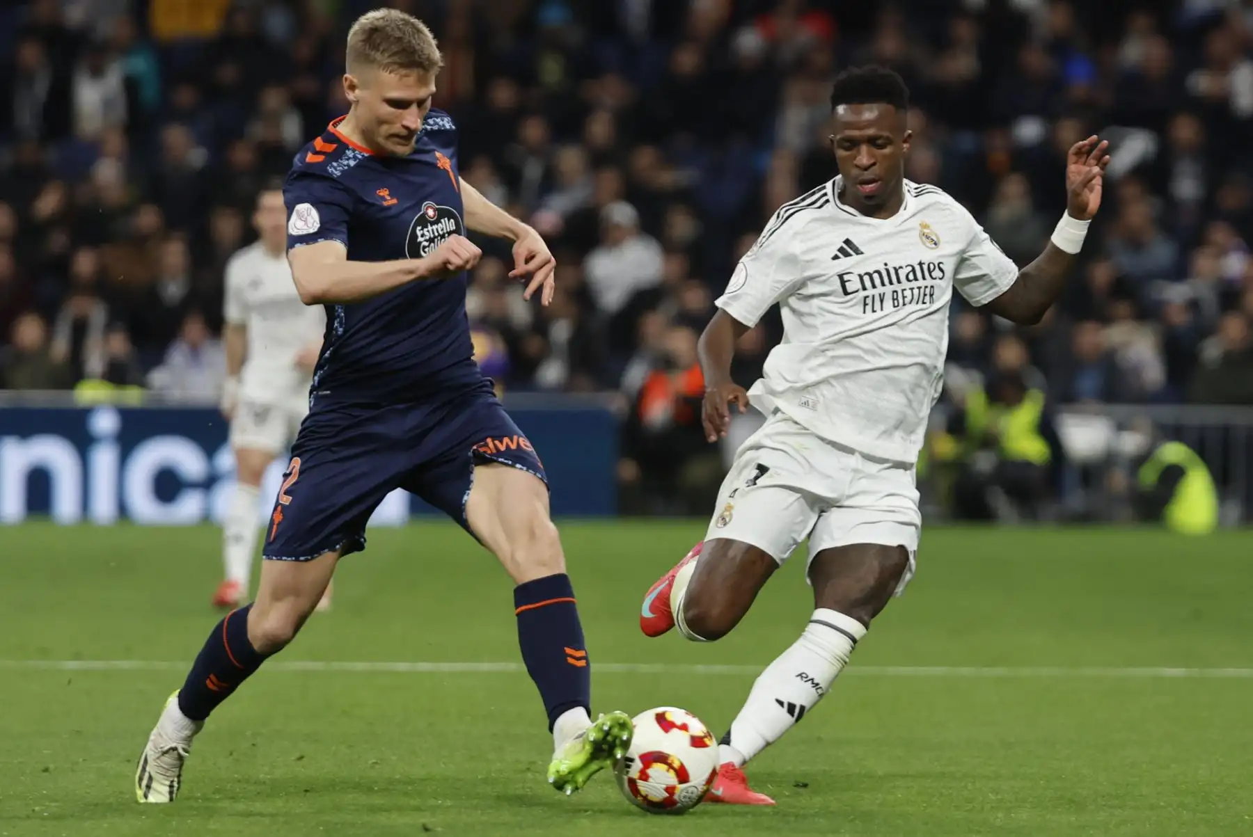 El delantero brasileño del Real Madrid Vinicius Jr. lucha con Carl Starfelt, del Celta, durante el partido de octavos de final de la Copa del Rey que Real Madrid y Celta de Vigo . EFE