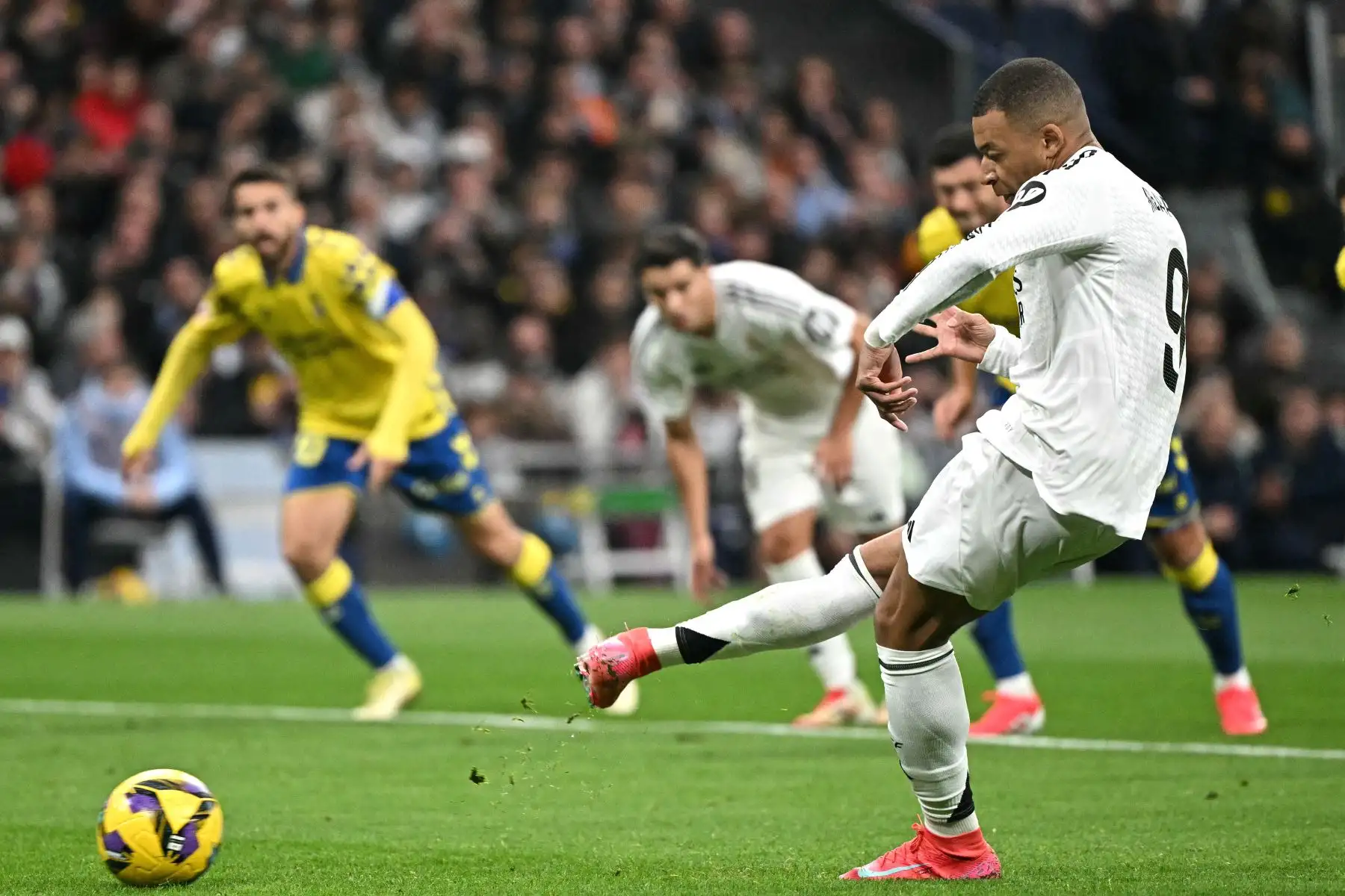 El delantero francés del Real Madrid, Kylian Mbappé, anota el primer gol de su equipo desde el punto de penalti durante el partido de fútbol de la liga española entre el Real Madrid CF y la UD Las Palmas en el estadio Santiago Bernabeu de Madrid.
Foto: AFP