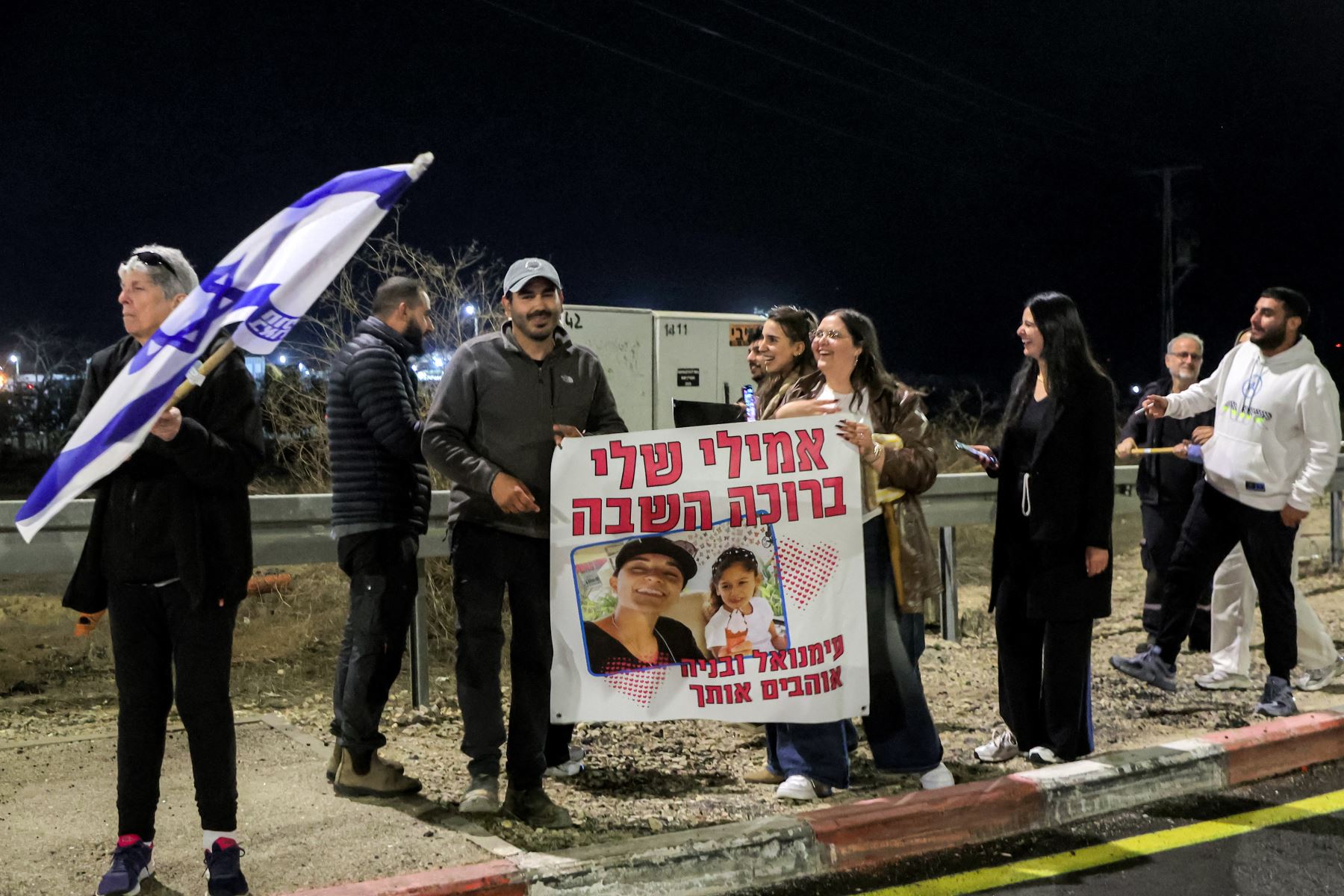 La gente sostiene un cartel saludando a Emily Damari, una de las tres rehenes israelíes liberadas que habían sido secuestradas durante los ataques del 7 de octubre de 2023 por militantes palestinos, mientras el convoy que la transportaba a ella y a los demás se acerca a Reim en el sur de Israel.
Foto: AFP