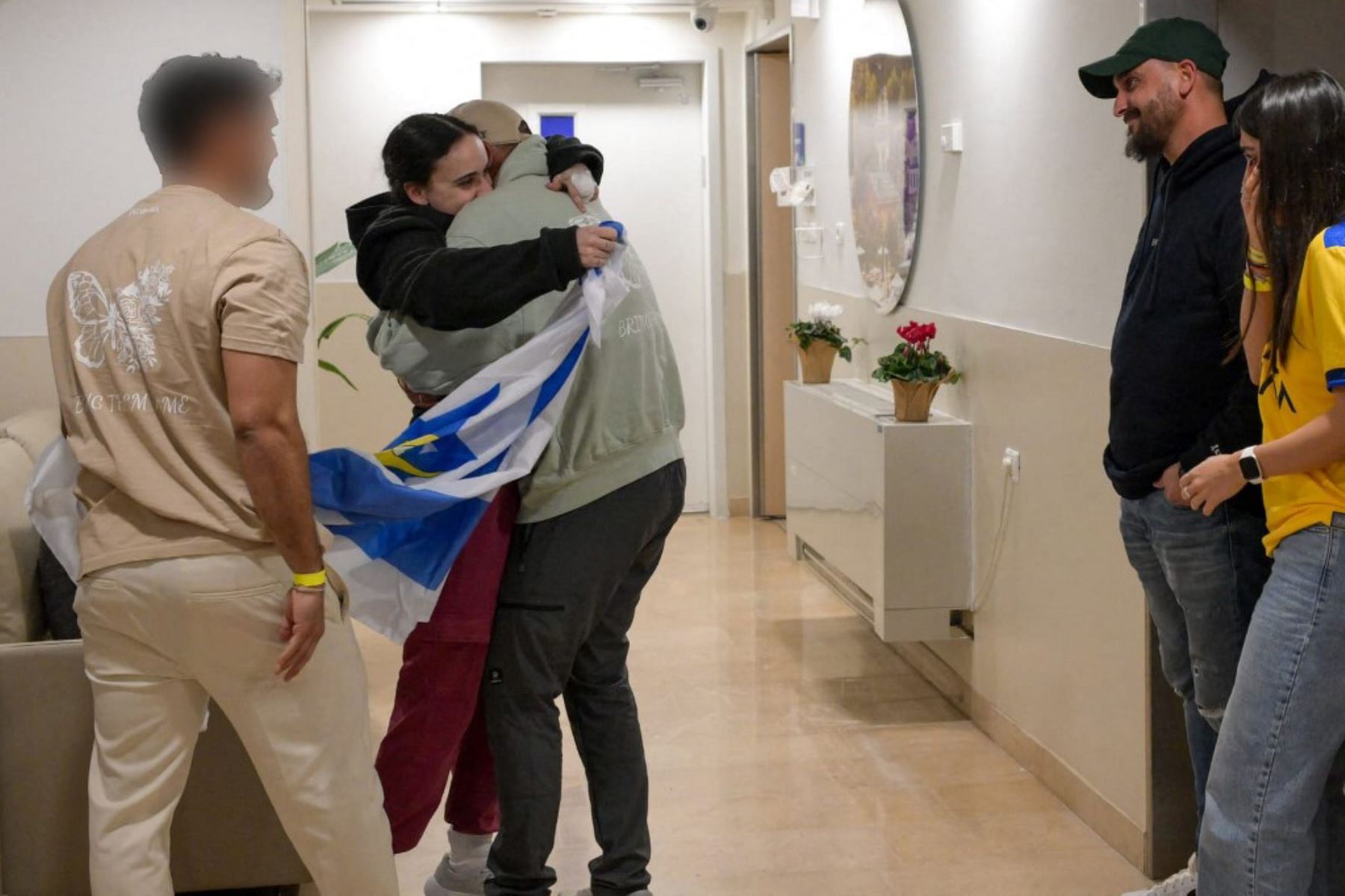 Rehén israelí Emily Damari abraza a un familiar dándole la bienvenida en el centro médico Sheba en Ramat Gan, cerca de Tel Aviv. Foto: AFP