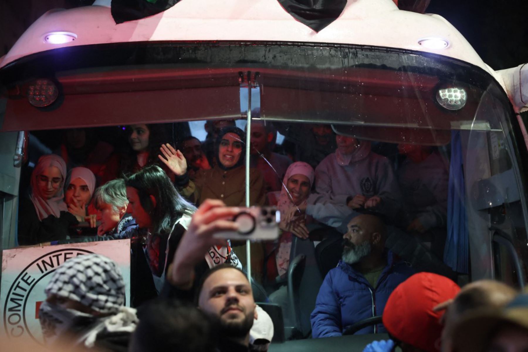 Los prisioneros palestinos liberados de la cárcel por Israel bajo una tregua con Hamás en Gaza saludan a la multitud desde el interior de un autobús de la Cruz Roja a su llegada en las primeras horas del 20 de enero de 2025 a la ciudad ocupada de Beitunia, en Cisjordania. Foto: AFP