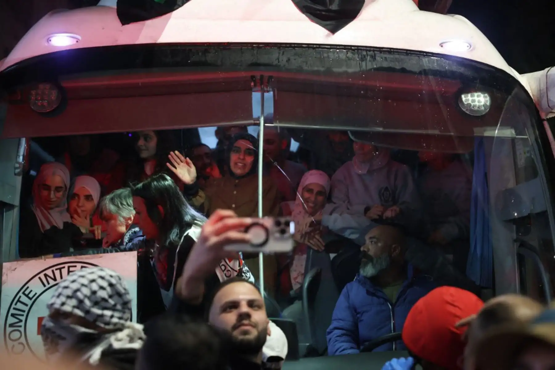 Los prisioneros palestinos liberados de la cárcel por Israel bajo una tregua con Hamás en Gaza saludan a la multitud desde el interior de un autobús de la Cruz Roja a su llegada en las primeras horas del 20 de enero de 2025 a la ciudad ocupada de Beitunia, en Cisjordania. Foto: AFP