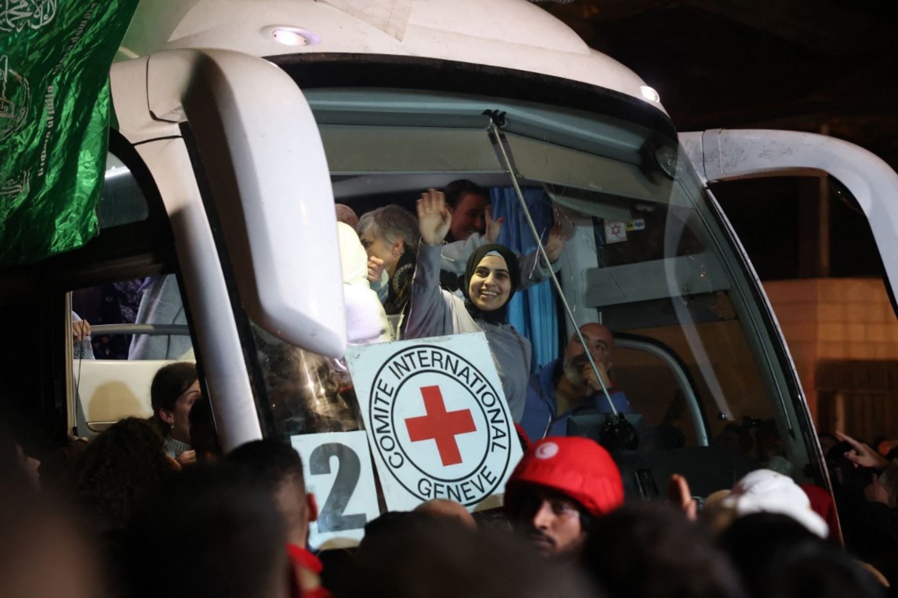 Los prisioneros palestinos liberados de la cárcel por Israel bajo una tregua con Hamás en Gaza saludan a la multitud desde el interior de un autobús de la Cruz Roja a su llegada en las primeras horas del 20 de enero de 2025 a la ciudad ocupada de Beitunia, en Cisjordania. Foto: AFP