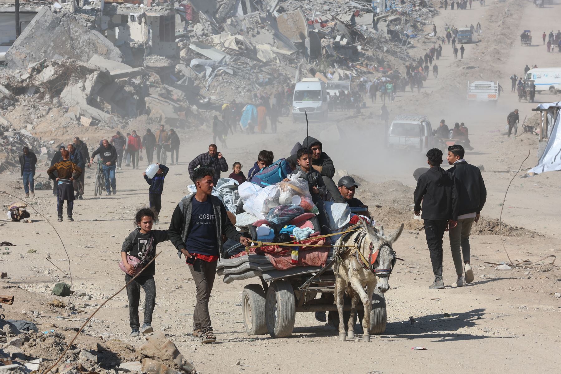 Los palestinos transportan sus pertenencias en Jabalia entre los escombros de los edificios destruidos mientras los desplazados se dirigen a las zonas del norte de la Franja de Gaza, en el tercer día de un acuerdo de alto el fuego en la guerra entre Israel y Hamás. AFP