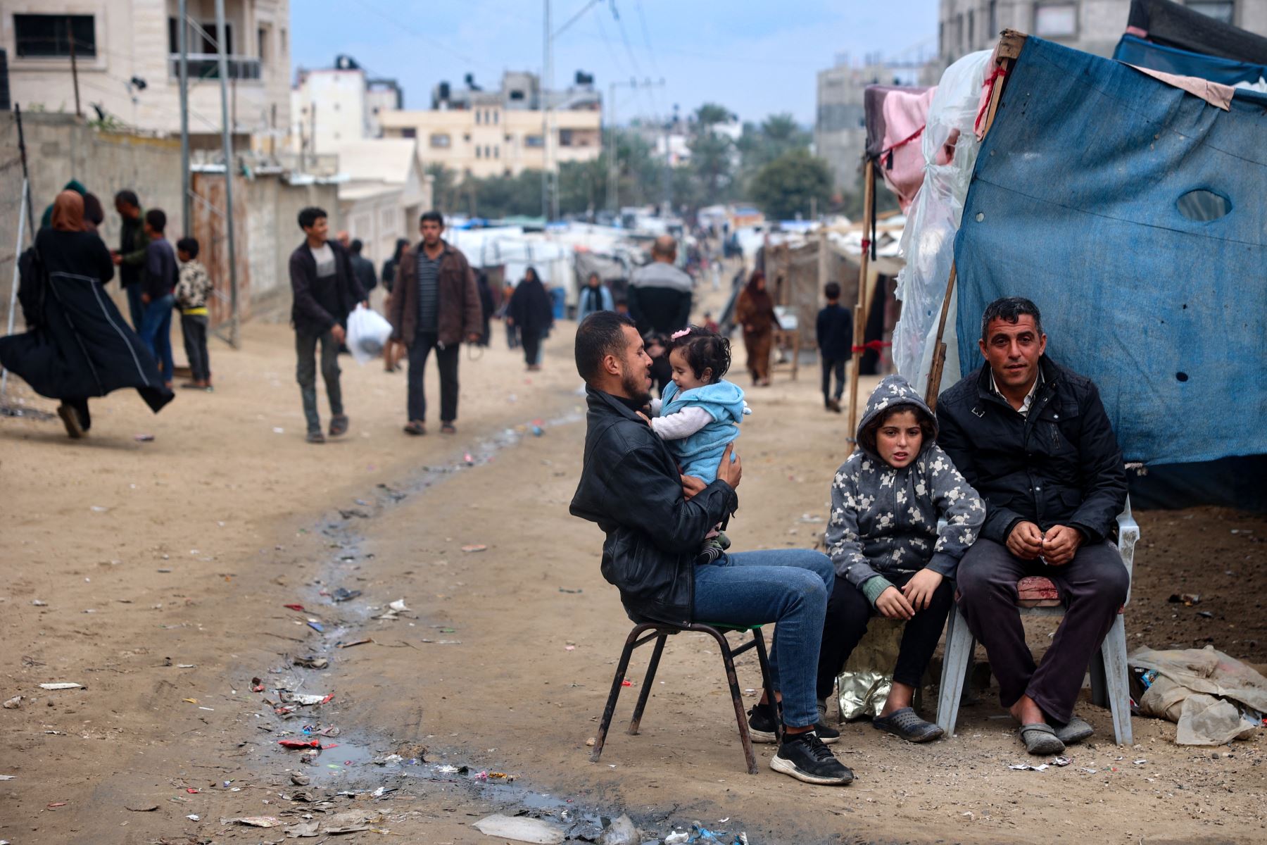 Palestinos desplazados se sientan frente a una tienda de campaña utilizada como refugio temporal en Deir el-Balah, en el centro de la Franja de Gaza. AFP