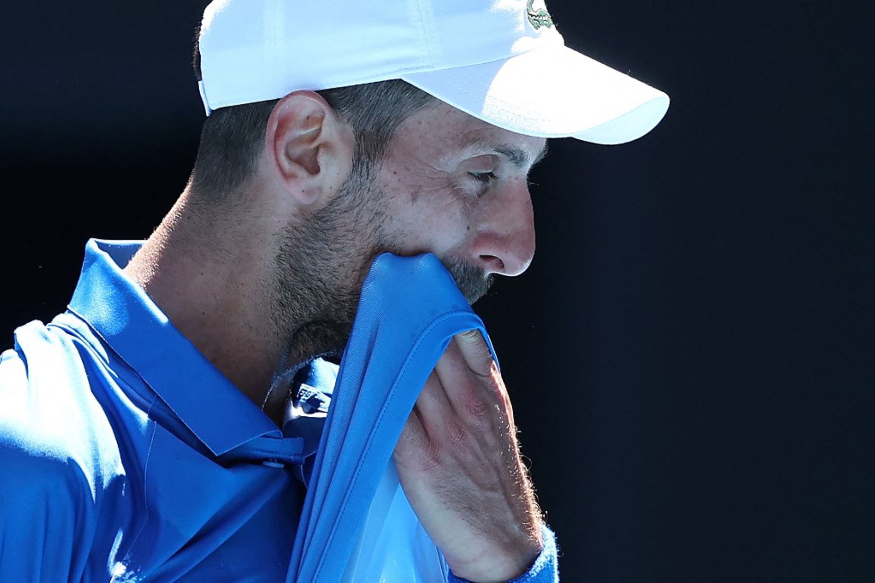 El serbio Novak Djokovic se limpia la cara entre partidos durante su partido de semifinales individuales masculino contra el alemán Alexander Zverev en el día trece del torneo de tenis Abierto de Australia en Melbourne. Foto: AFP