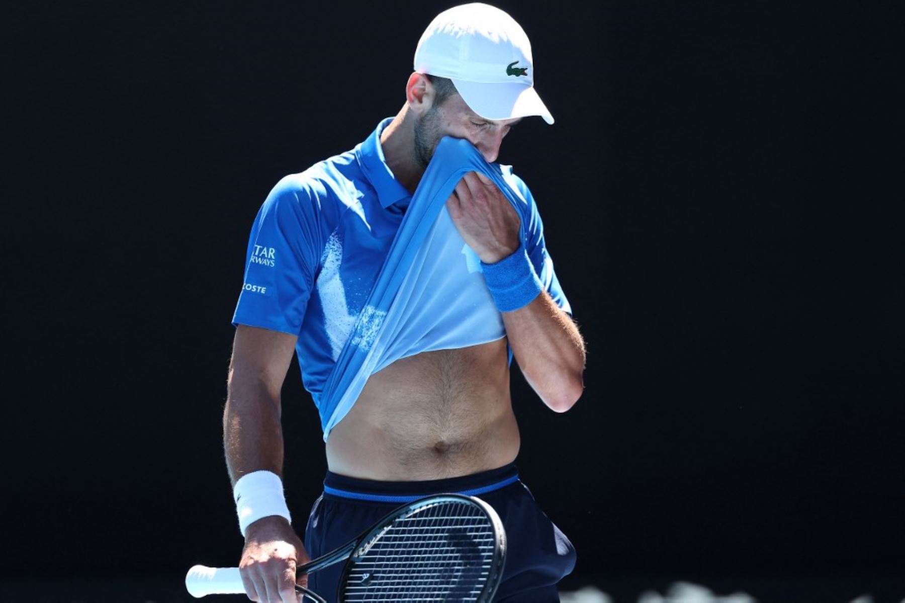 El serbio Novak Djokovic se limpia la cara entre partidos durante su partido de semifinales individuales masculino contra el alemán Alexander Zverev en el día trece del torneo de tenis Abierto de Australia en Melbourne. Foto: AFP