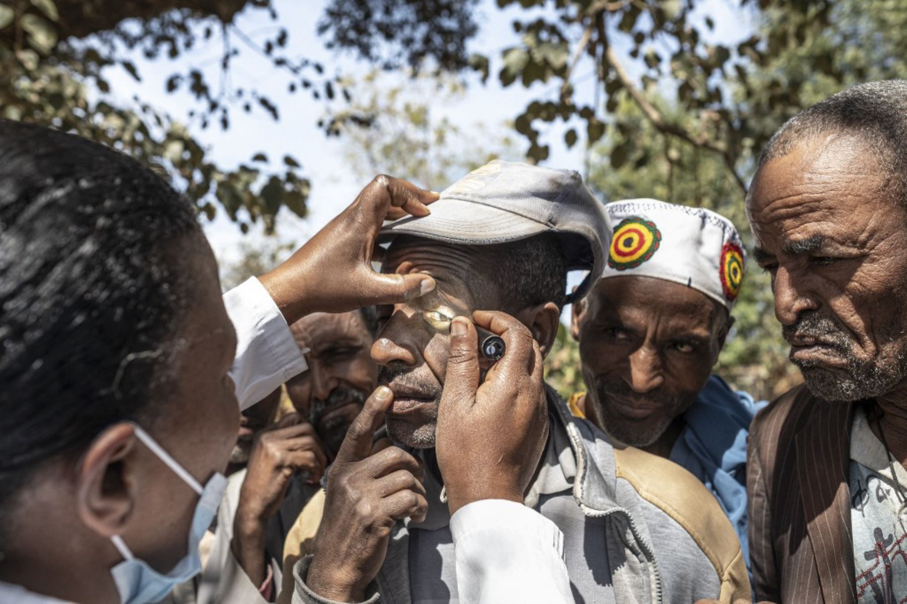 La enfermera oftalmológica Gizachew Abebe, de 60 años y otros miembros del equipo del Hospital Grarbet Tehadiso Mahber (GTM), distribuyen ungüentos antibióticos para el tracoma en un pueblo cerca de Butajira. El tracoma es responsable de cegar o deteriorar visualmente a casi dos millones de personas en todo el mundo. Es causada por la infección con la bacteria Chlamydia trachomatis, que se propaga a través del contacto con los ojos o la nariz de las personas infectadas. Foto: AFP