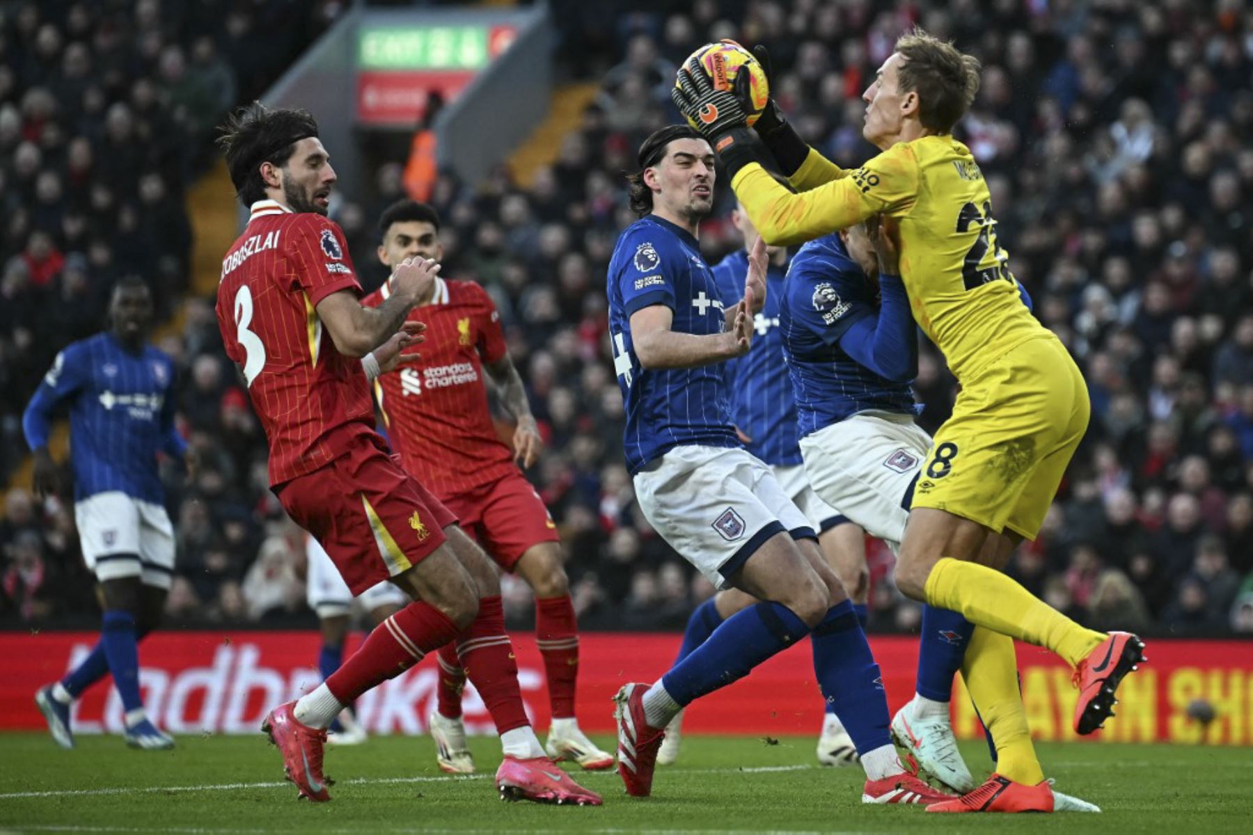 El portero inglés de Ipswich Town #28, Christian Walton (R) salva al centrocampista húngaro del Liverpool #08 Dominik Szoboszlai durante el partido de fútbol de la Premier League inglesa entre Liverpool e Ipswich Town en Anfield en Liverpool, noroeste de Inglaterra, el 25 de enero de 2025. (Foto de Paul ELLIS / AFP)