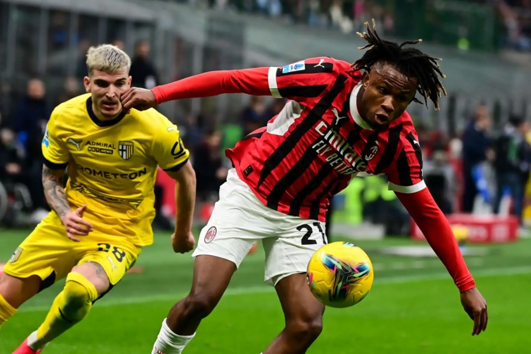 El centrocampista nigeriano del AC Milan #21 Samuel Chukwueze (L) lucha por el balón con el delantero rumano del Parmaís #28 Valentin Mihaila (R) durante el partido de fútbol de la Serie A italiana entre el AC Milan y el Parma en el Estadio San Siro de Milán, el 26 de enero de 2025. (Foto de Piero CRUCIATTI / AFP)