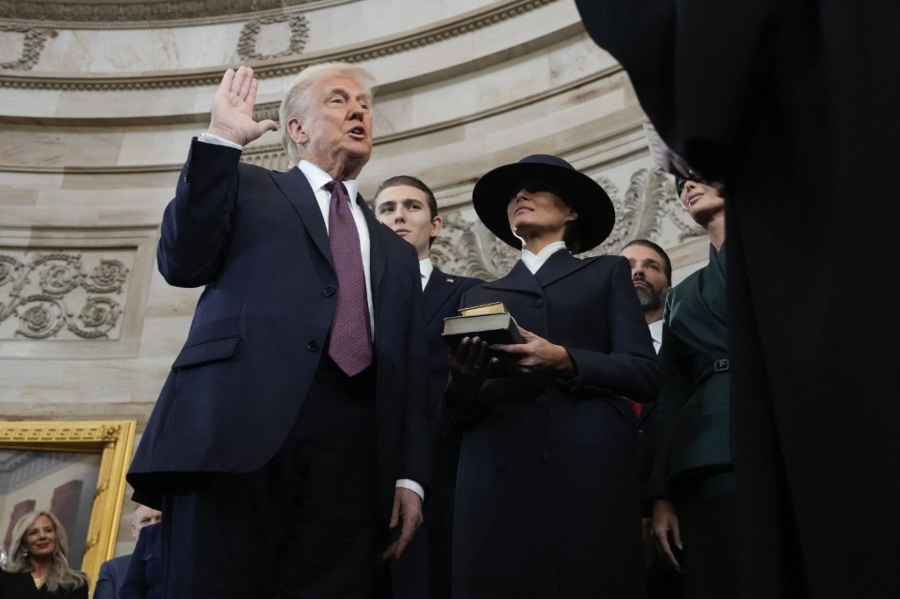 Donald Trump es juramentado como el presidente número 47 de los Estados Unidos por el presidente del Tribunal Supremo, John Roberts, mientras Melania Trump sostiene la biblia. La ceremonia se realizó en el Capitolio ubicado en Washington D.C. (Foto de Morry Gash / POOL / AFP)