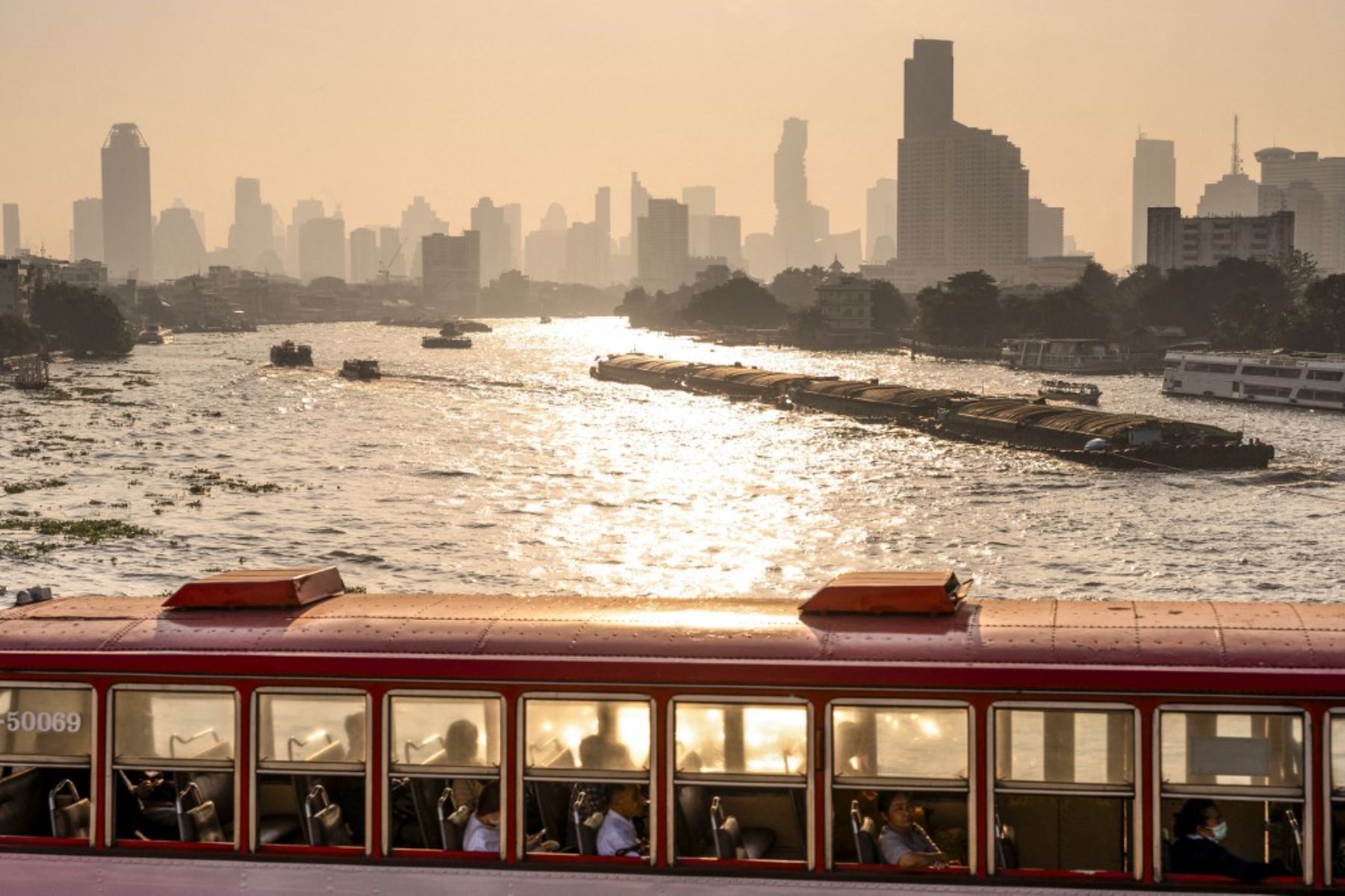 Un autobús conduce por un puente sobre el río Chao Phraya en medio de altos niveles de contaminación del aire en Bangkok el 21 de enero de 2025. (Foto de Chanakarn Laosarakham / AFP)