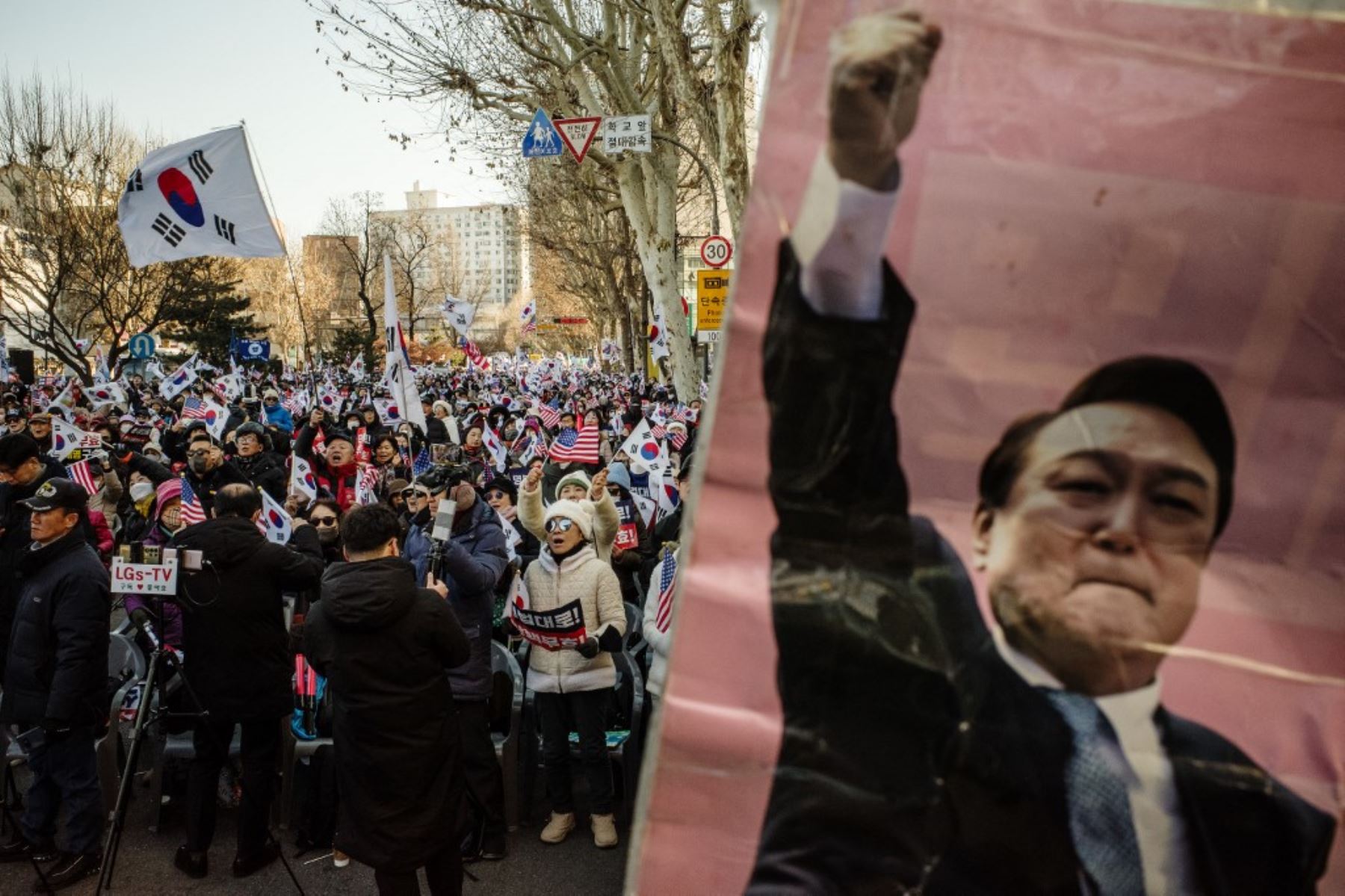 Los partidarios del presidente destituido de Corea del Sur, Yoon Suk Yeol (en la foto en el cartel R) asisten a un mitin en una carretera cerca del Tribunal Constitucional de Seúl el 23 de enero de 2025, después de que Yoon llegara al tribunal para las audiencias que decidirán si lo destitirán del cargo. (Foto de ANTHONY WALLACE / AFP)