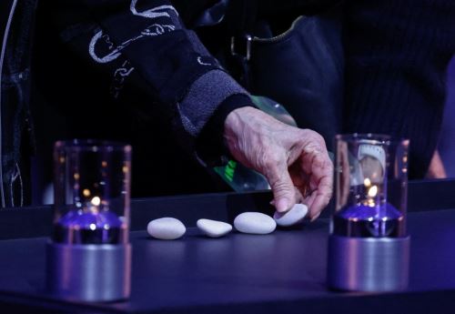 Un sobreviviente del Holocausto coloca piedras entre velas durante las conmemoraciones por el 80 aniversario de la liberación del campo de concentración y exterminio nazi alemán de Auschwitz-Birkenau por parte del Ejército Rojo, en el sitio del campo de concentración de Auschwitz el 27 de enero de 2025, en Oswiecim, Polonia. Foto: AFP